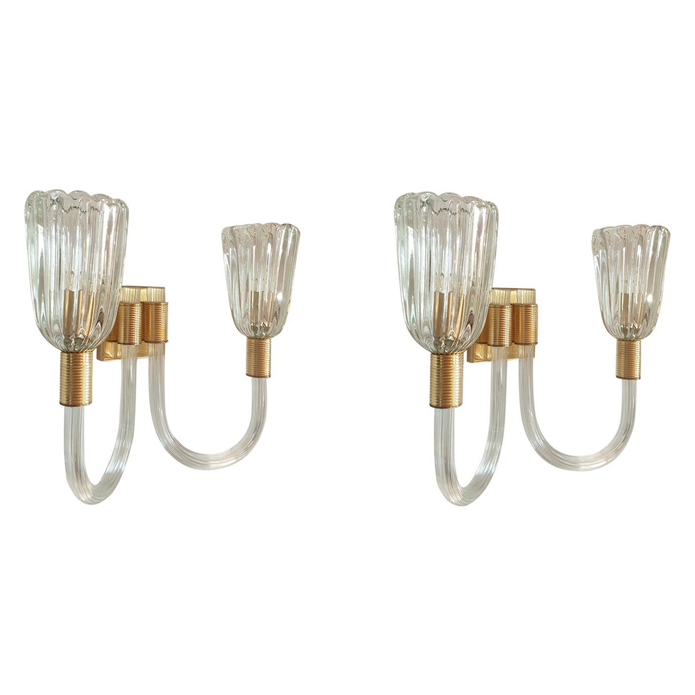 Pair of Mid-Century Modern wall sconces, in hand blown Murano glass, attributed to Barovier & Toso Italy, 1960s.
The vintage sconces are made of clear and thick hand blown Murano glass and polished brass mounts.
They have two lights each and are