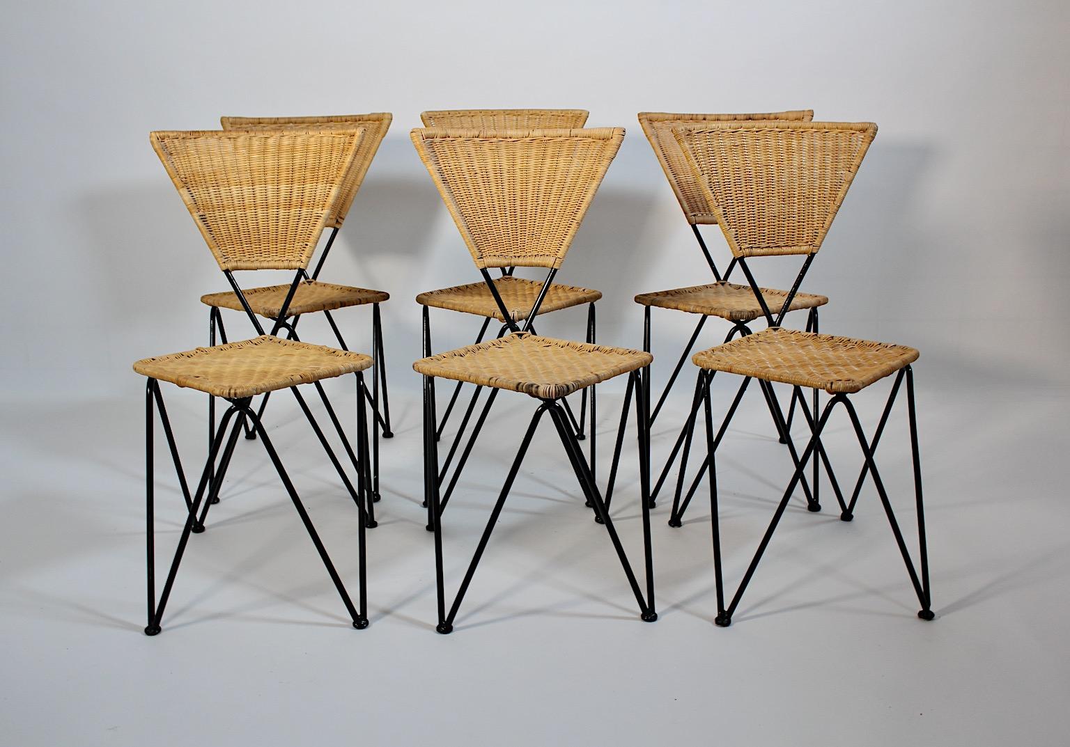 Mid Century Modern organic vintage six dining chairs from rattan and 
black metal by Sonett 1950s Vienna.
A charming set of six dining chairs or chairs triangle shape from woven rattan for seat and back and black lacquered metal frame pin