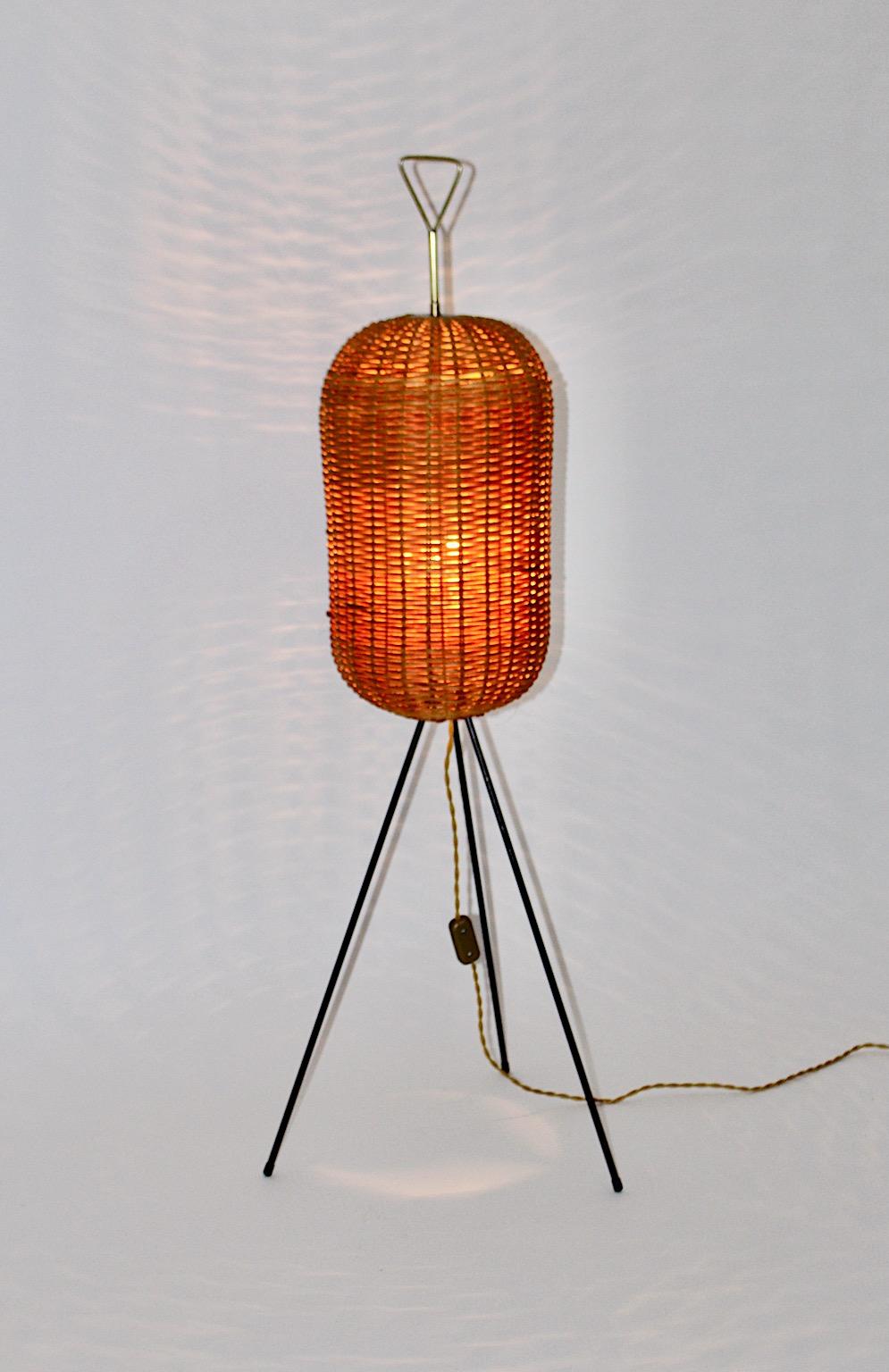 Mid-Century Modern vintage organic trilegged floor lamp from rattan, brass and metal 1950s Vienna.
While the lamp shade from rattan network bee hive like is in very good condition and shows caramel brown color tone, the frame made from brass and