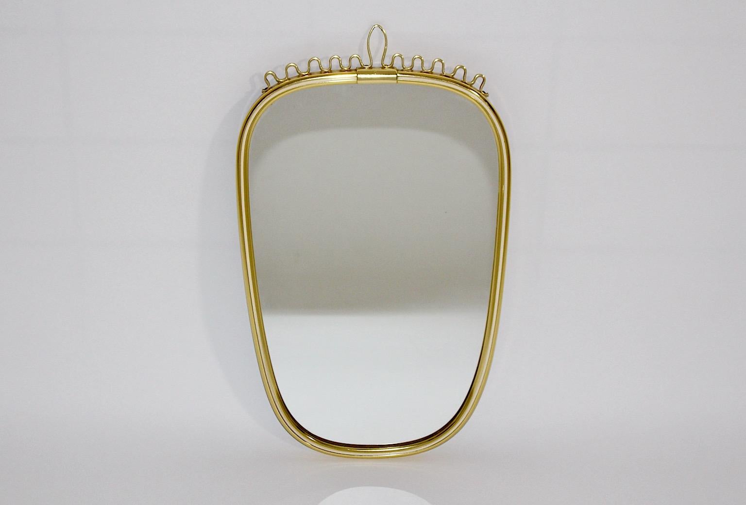 Mid-Century Modern vintage wall mirror oval like from brassed metal with white inner edge and slightly curved details at the upper part 1960s Germany.
A lovely and elegant wall mirror in oval shape with nice curls at the upper part.
This beautiful