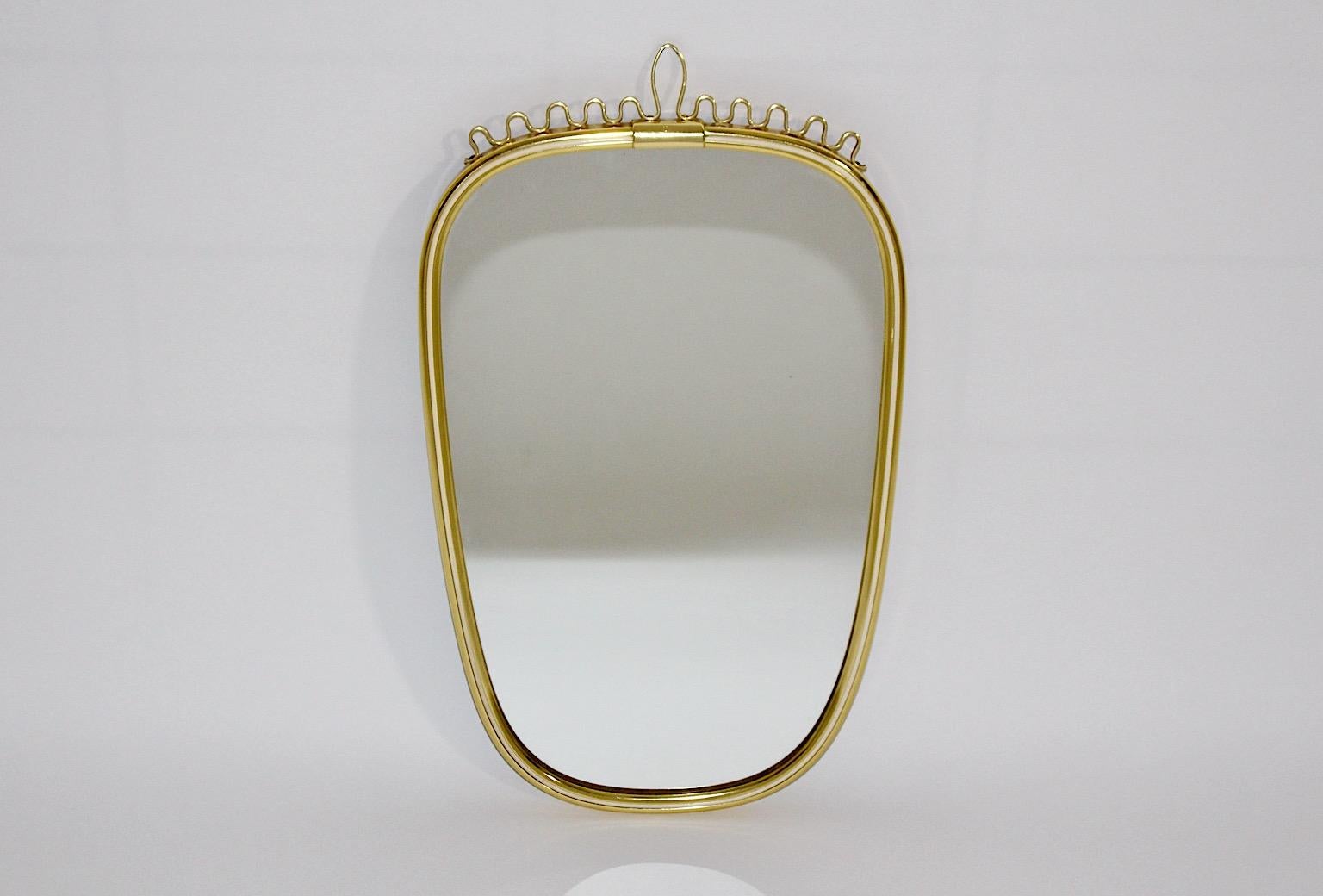 Miroir mural vintage Mid-Century Modern de forme ovale en métal laitonné avec bord intérieur blanc et détails légèrement incurvés sur la partie supérieure. 1960s Germany.
Un joli et élégant miroir mural de forme ovale avec de belles boucles sur la