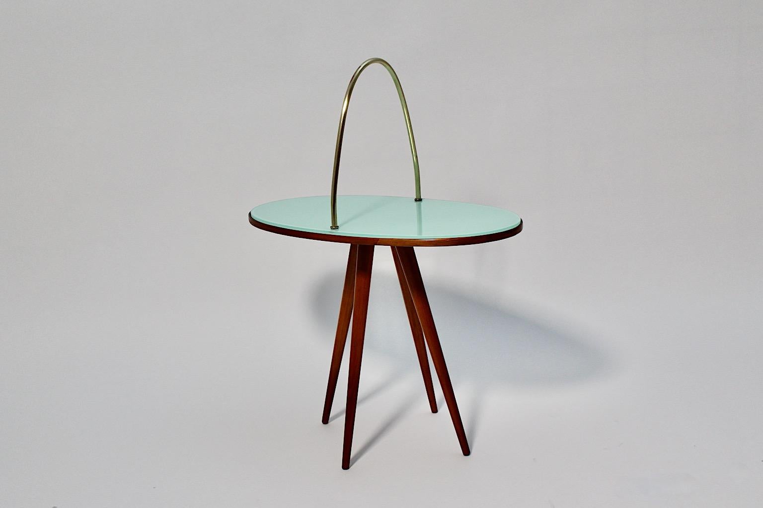Mid-Century Modern Vintage oval side table from cherrywood, green glass and brass 1950s Italy.
An amazing side table or coffee table from shellac polished cherrywood topped with a green glass plate and a nice brass handle.
This wonderful green