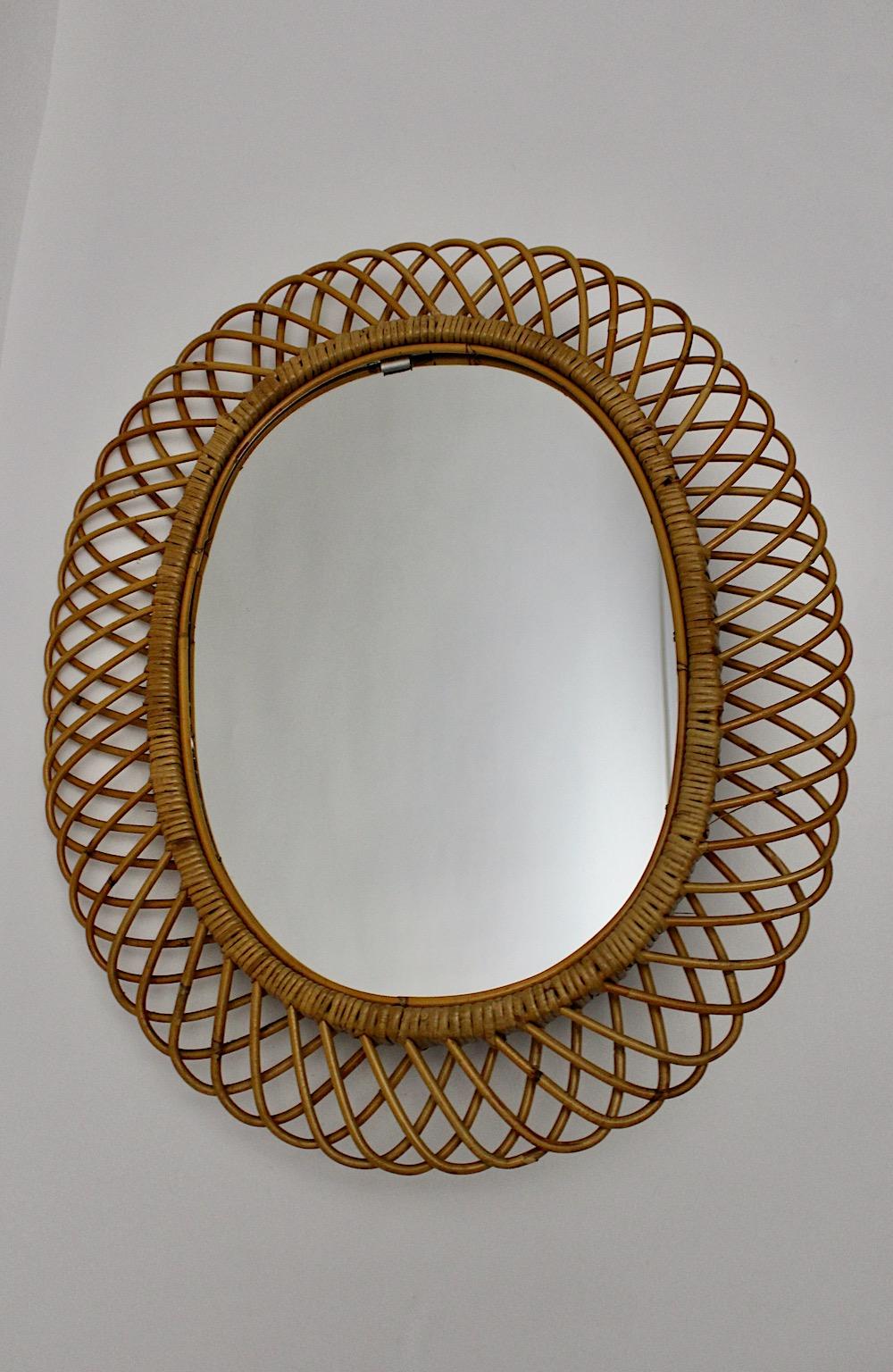 Mid-Century Modern vintage organic sunburst mirror or wall mirror from rattan and mirror glass, 1960s Italy.
While the large size from this sunburst mirror allows to hang up in an entryway or about a fireplace the charming sunburst- like mirror