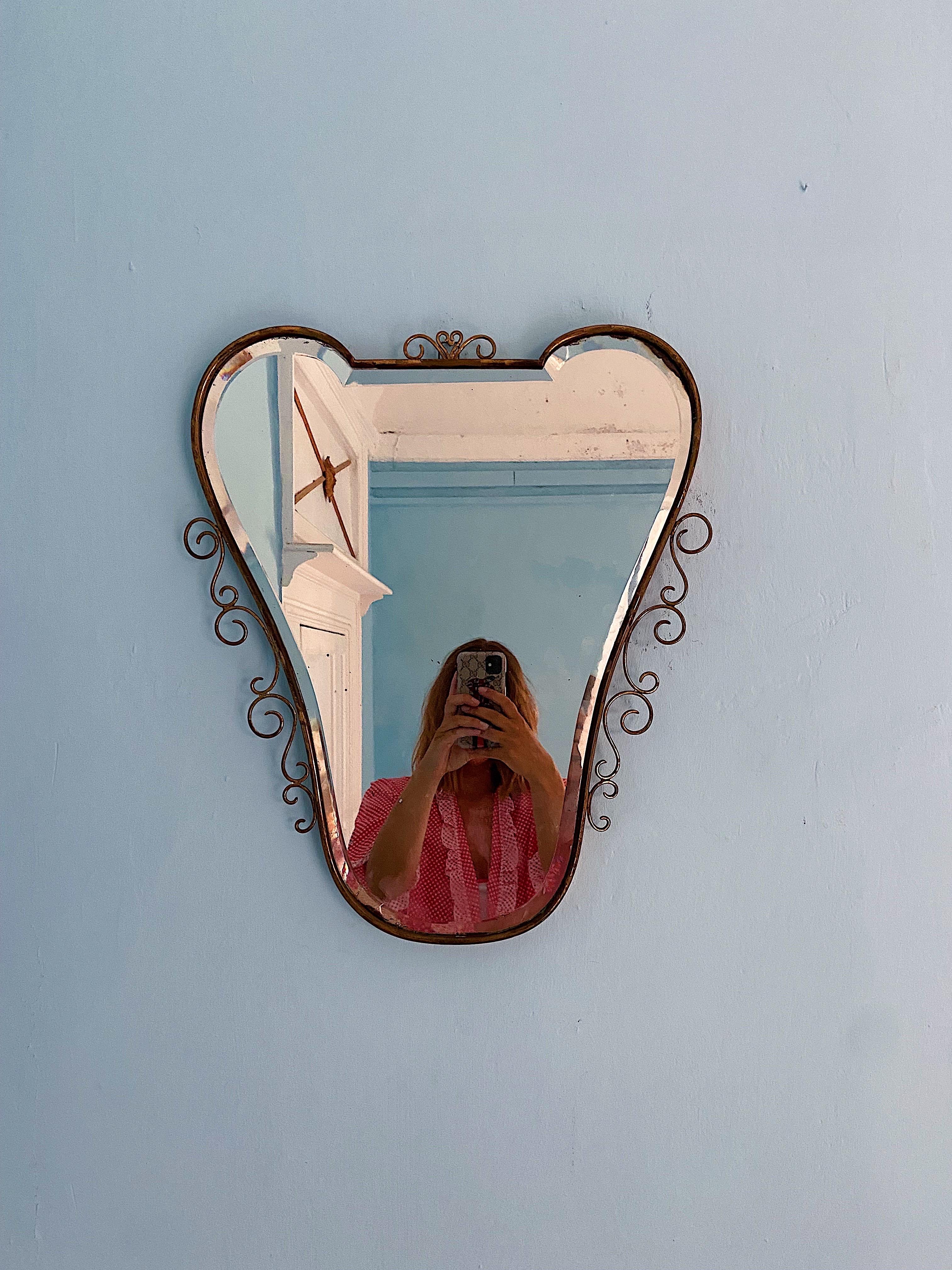 Mid-Century Italian wall mirror attributed to Gio Ponti. Original unrestored mirror with brass frame (circa 1950s). Very elegant shape. The backside is in solid wood and retains original hook for hanging. You can shine the brass, but I have chosen