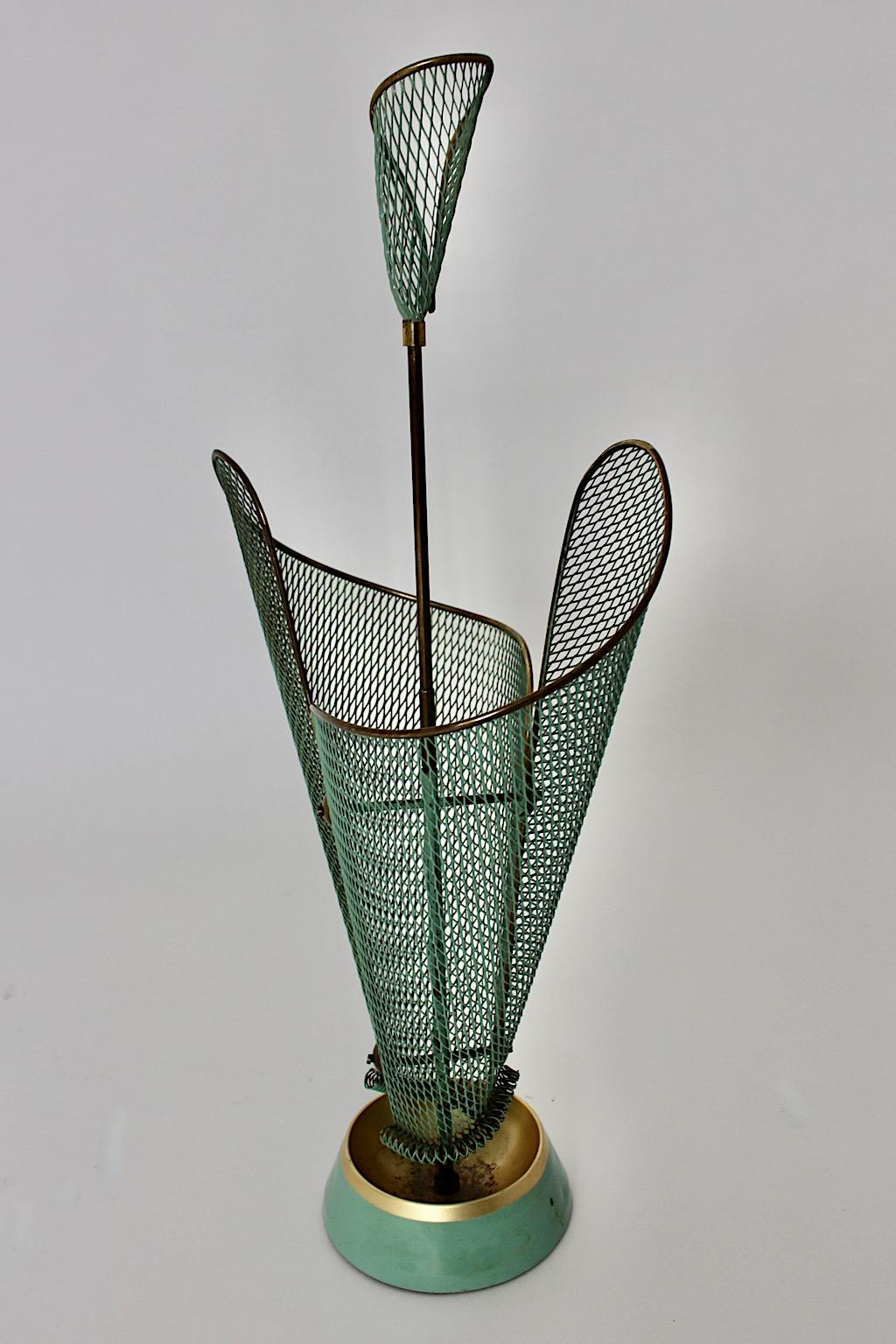 Mid-Century Modern vintage umbrella Stand from mesh metal in pastel green color tone by Schiwa Luxus 1950s Germany.
A stunning umbrella Stand from metal mesh in pastel green and brass details with a cast iron base and an integrated drip cup.
The