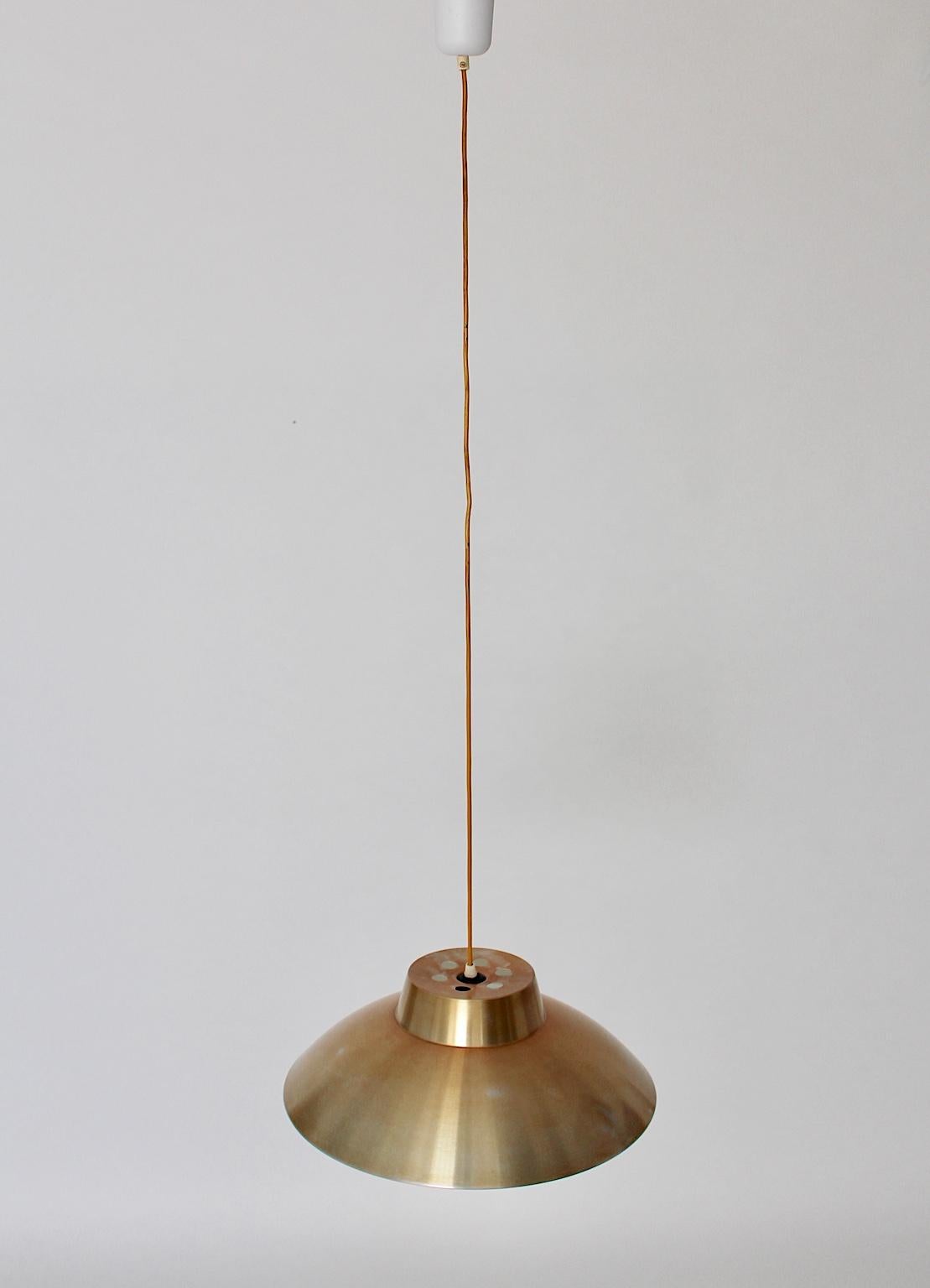 Mid Century Modern vintage pendant or hanging lamp by Philips Netherlands, which was designed in the 1960s.
The good looking aluminum lamp shade shows a golden eloxated surface, while the form features a wonderful calm stylish design.
The vintage