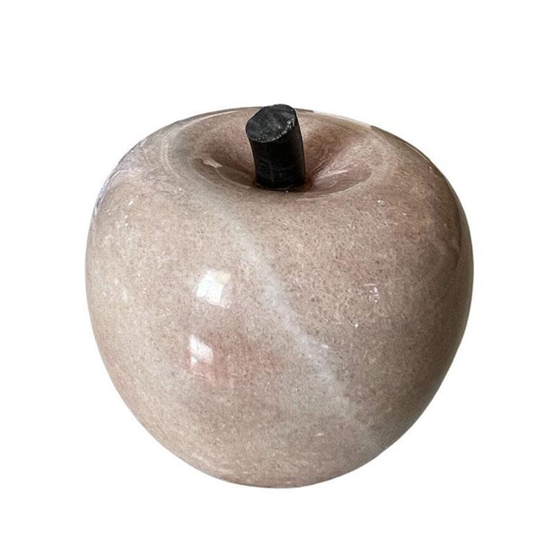 A pretty pink vintage carved stone apple. Created from either alabaster, granite, or rose quartz this heavy piece will be a great addition to a desk or bookshelf. It is round with some white veining. The stem is created from a black stone and tilts