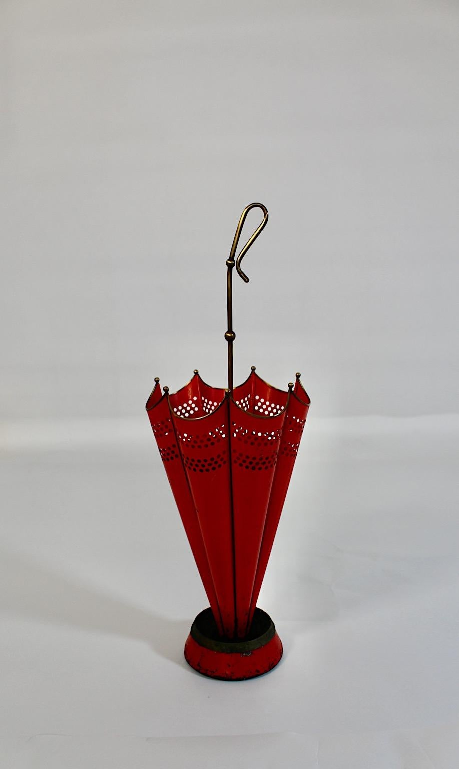 Mid Century Modern Vintage umbrella stand from red lacquered metal and brass 1950s Italy.
A charming umbrella stand in umbrella shape from red lacquered metal and brass details.
While the stunning shape from this umbrella stand allows to install it