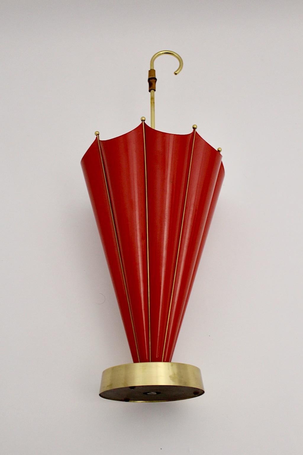 Mid-Century Modern vintage umbrella stand or cane holder from red lacquered metal, brass and bamboo 1950s Italy.
While the cast iron base supports the umbrella stand for a safe standing, the body from red lacquered metal with brass details umbrella