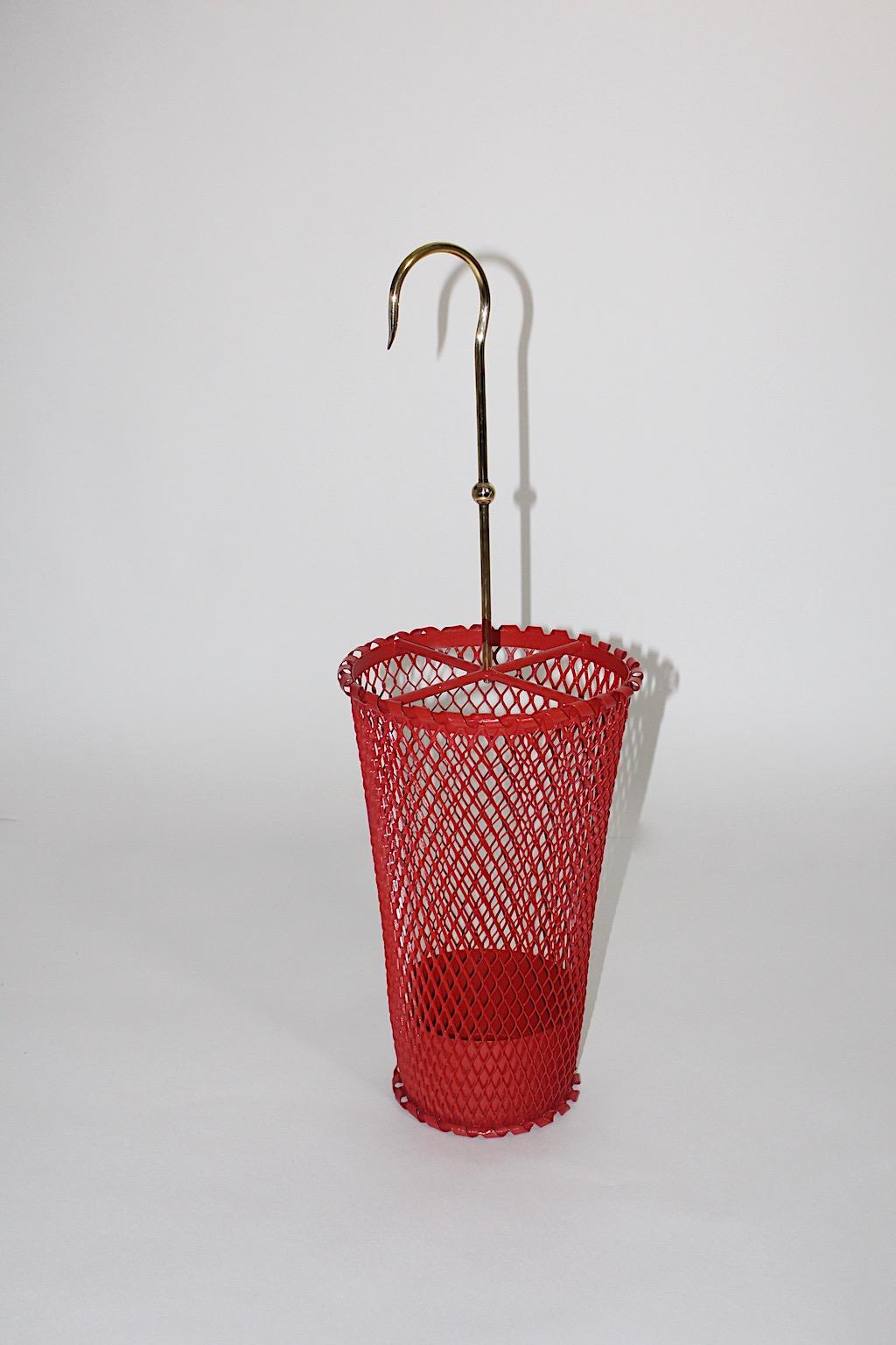 Mid-Century Modern vintage red brass umbrella stand by Mathieu Matégot for Ateliers Matégot, France, 1950s.
An amazing umbrella stand from red lacquered metal and brass.
This vintage umbrella stand features a newly red lacquered iron mesh body,