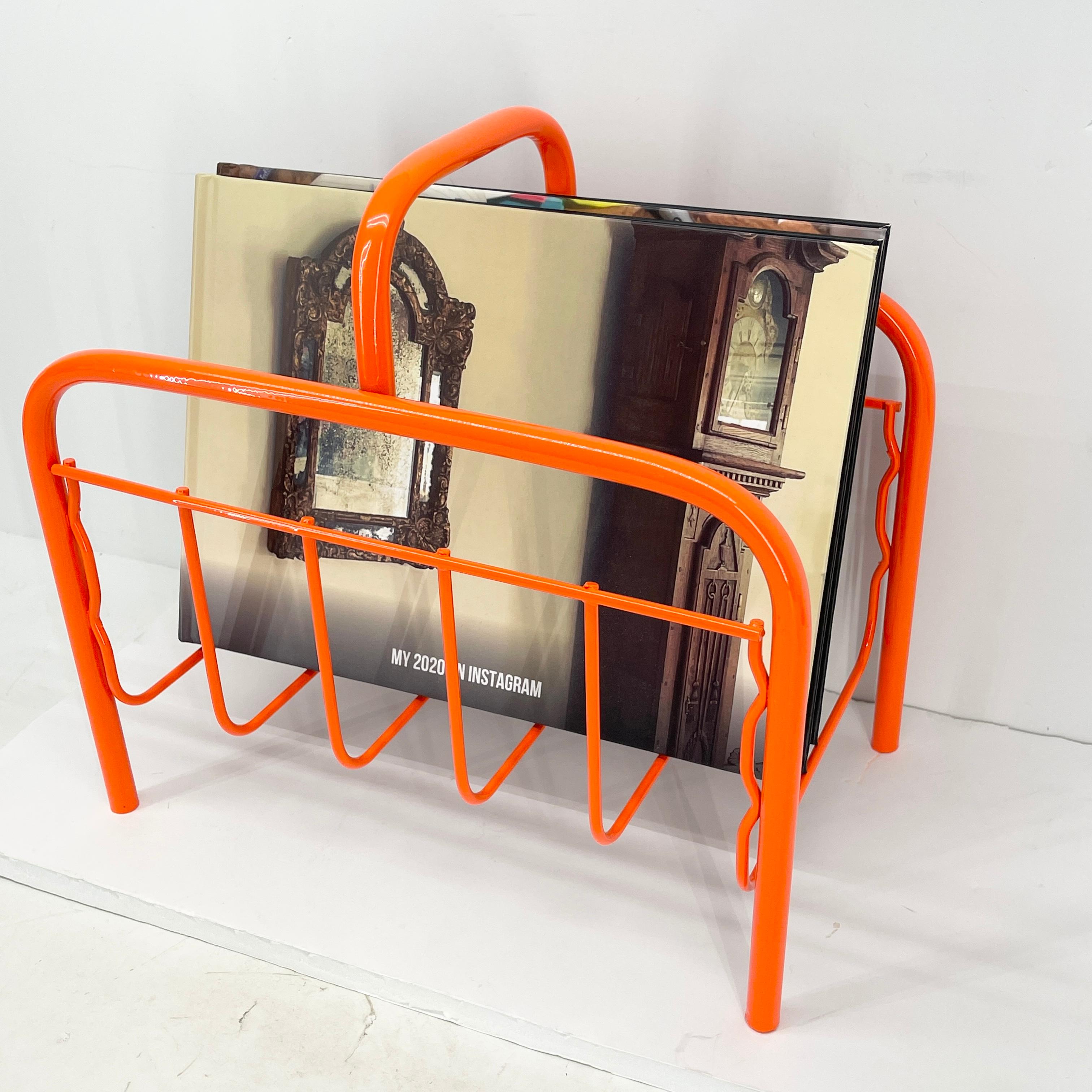 Mid-Century Modern magazine or record albums rack freshly powder coated in bold bright red orange. This rack is small but mighty. It will make a statement in any room. Sturdy metal rack holds magazines or vinyl records and is a fun addition to an