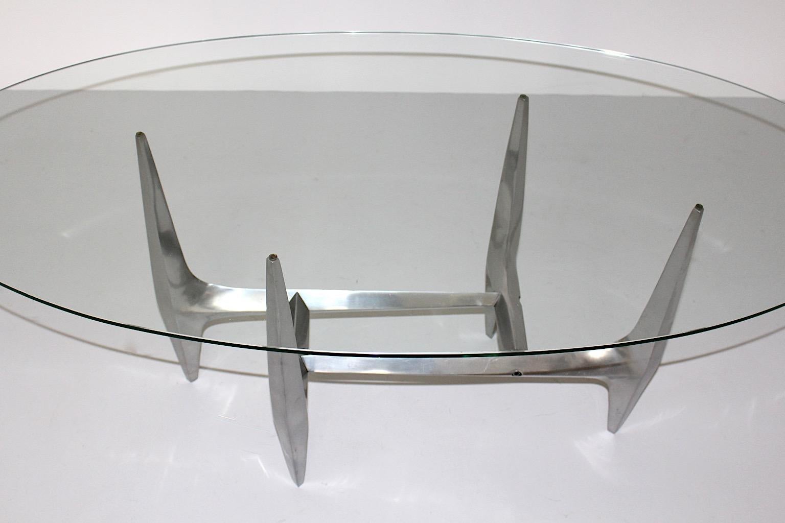 Mid Century Modern sculptural vintage coffee table by Knut Hesterberg 1960s from aluminum and clear glass.
A high-quality vintage coffee table by Knut Hesterberg from polished aluminum base and an oval shaped clear glass top. Produced by Ronald
