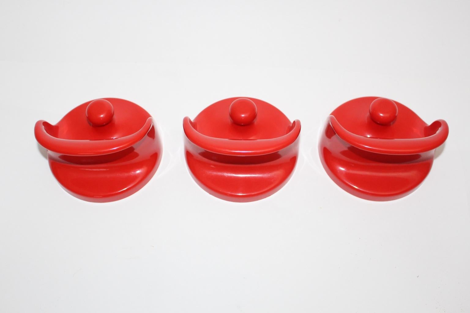 Set vintage di tre staffe da parete o appendiabiti in plastica di colore rosso, disegnato da Olaf Bohr negli anni '60 in Germania e prodotto da Kartell. 
È facile fissare gli appendiabiti alla parete.
Le condizioni vintage sono molto buone.
Misure