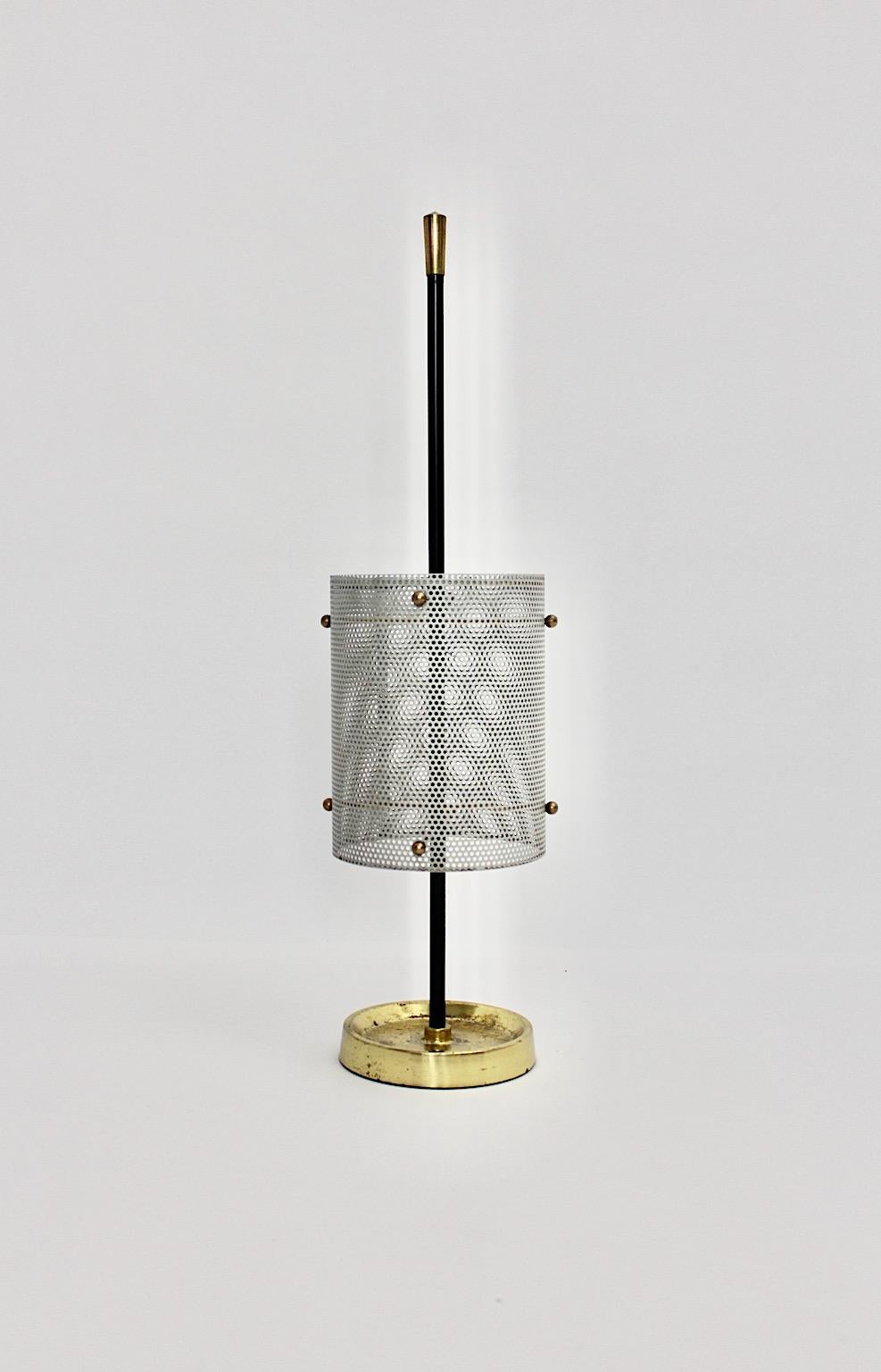 Mid-Century Modern vintage umbrella stand or cane holder from metal in soft grey color with brass details 1960s Germany.
A stunning vintage umbrella stand in cylindral shape from perforated soft grey lacquered sheet metal with brass details and