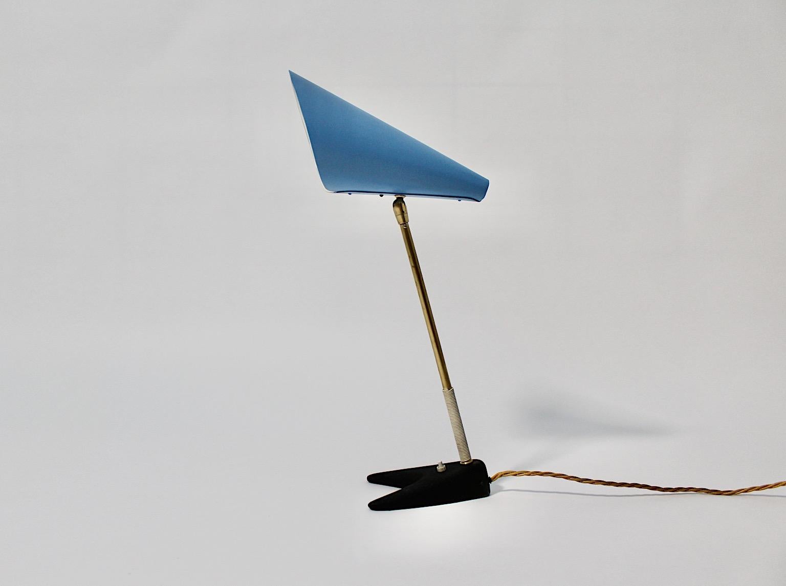 Mid-Century Modern vintage table lamp in black and blue with brass details by Kalmar 1950s Vienna.
A wonderful iconic table lamp or desk lamp by Kalmar features a fabulous blue lacquered cone shaped shade and a brass stem with string handle.
The