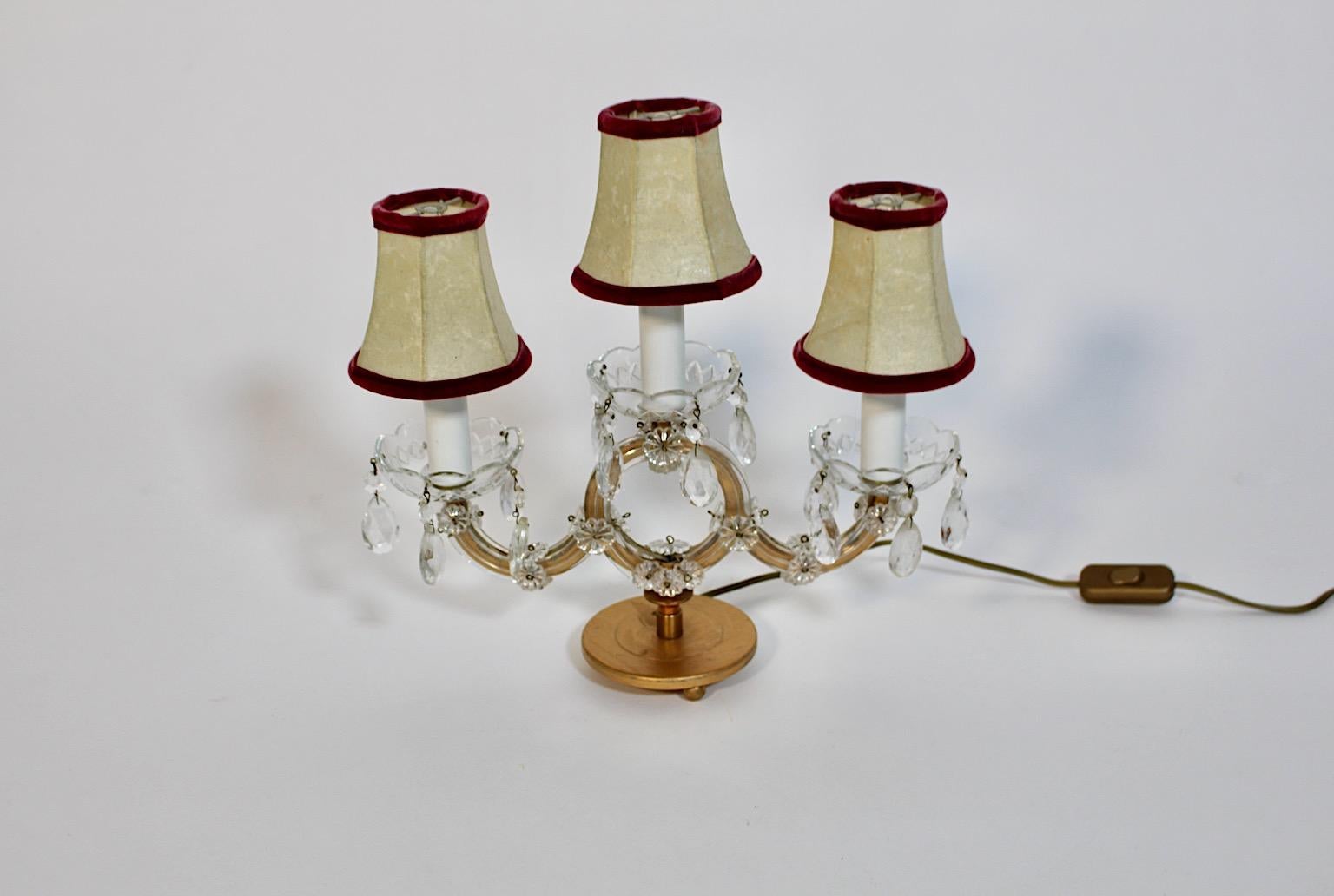 Lampe de table vintage Mid Century Modern en métal doré et verre des années 1960 en Autriche.
Une magnifique lampe de table ou de chevet avec trois douilles E 14 en métal doré, verre et pierres de verre.
De délicates pierres de verre sont disposées