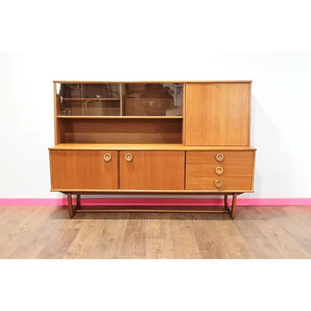 Introducing the Mid Century Modern Vintage Tall Credenza by Portwood, a stunning piece of furniture from the renowned British furniture maker. This tall credenza is the perfect blend of mid century modern design and vintage flair, making it a