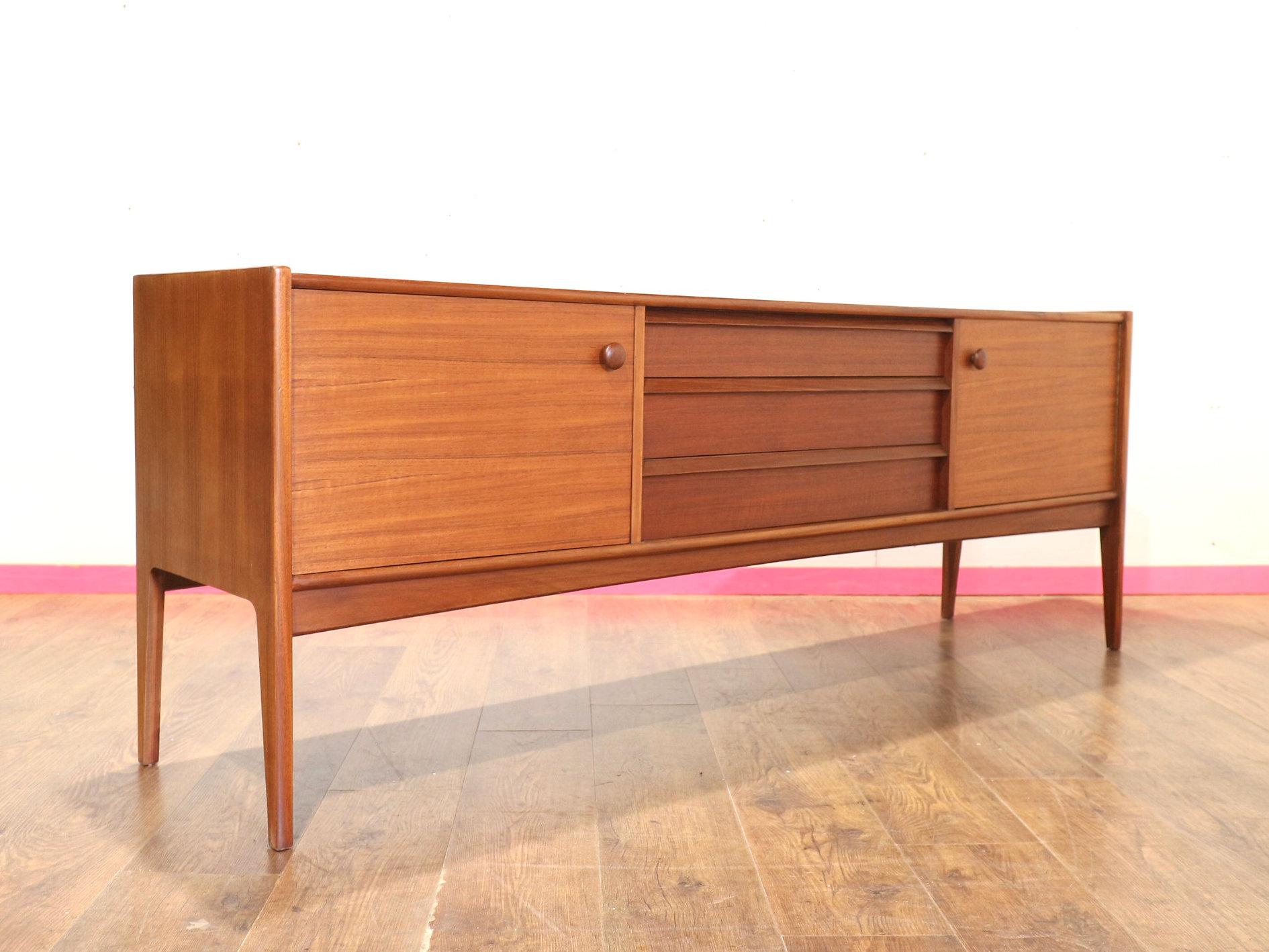 This Mid Century Modern Vintage Afromosia Sideboard Credenza by Younger is a beautiful and rare find for any mid-century furniture enthusiast. Designed by John Herbert for A.Younger Ltd, this stunning teak and afrormosia wood sideboard is a true