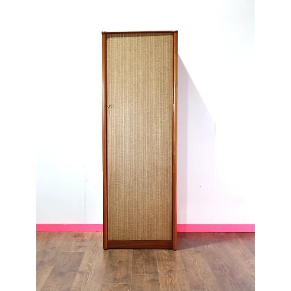 Add a touch of unique style and functionality to your space with this Mid Century Modern Vintage Teak and Rattan Armoire Wardrobe. The combination of teak and rattan give this piece a beautifully delicate yet sturdy aesthetic. The single armoire