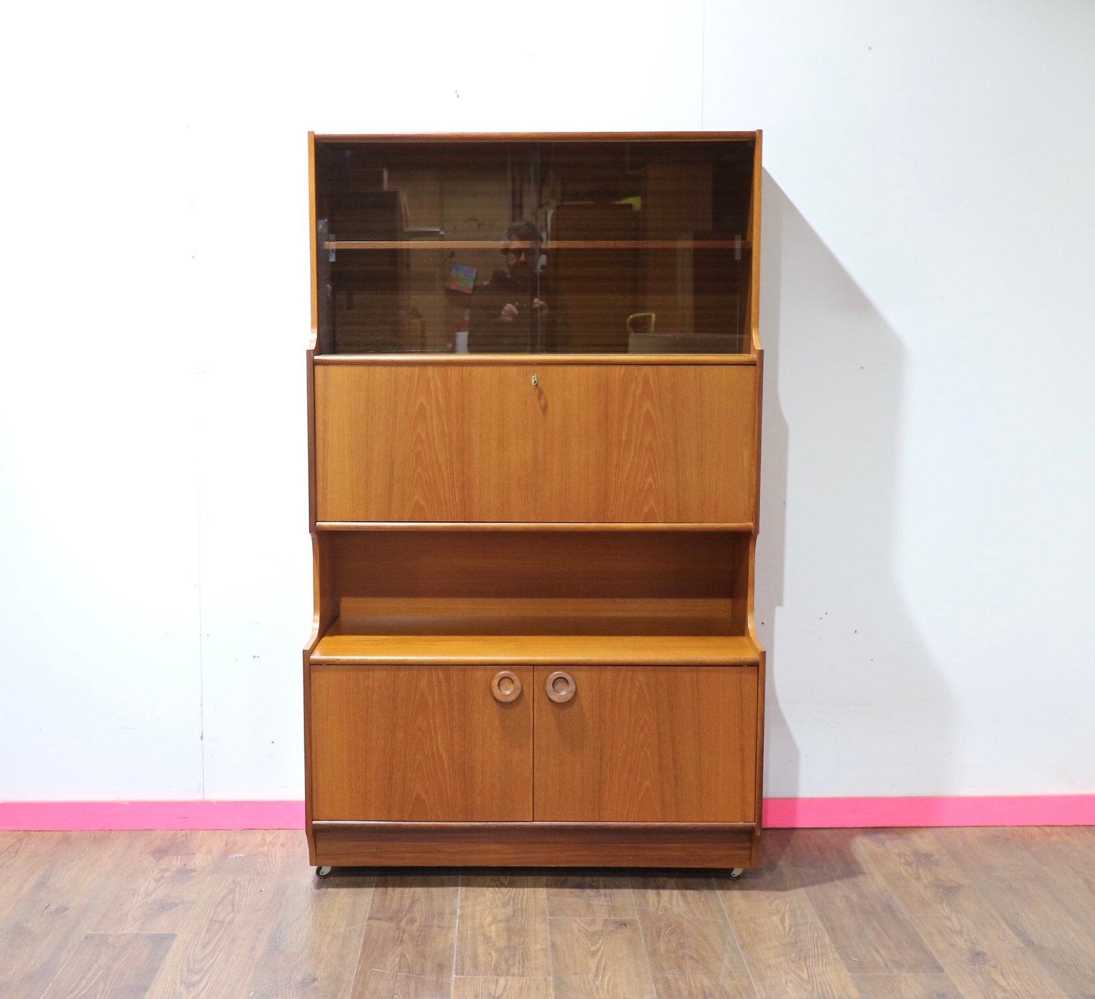 Scopri l'epitome della raffinatezza con questa libreria Mid Century Modern Vintage Display China Cabinet di Portwood, un favoloso pezzo realizzato dal rinomato produttore di mobili britannico. Il grande spazio di archiviazione si combina