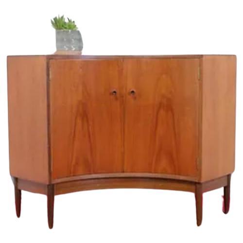 Add a touch of timeless elegance to your home decor with this Mid Century Modern Vintage Teak Danish Style Cabinet by Greaves and Thomas. Crafted in the 1960s, this beautiful piece showcases the exquisite craftsmanship of the renowned British