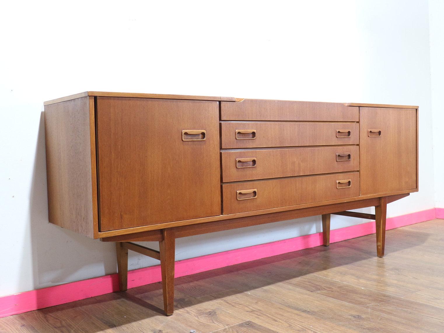 Este aparador aparador vintage moderno de mediados de siglo de Beautility es una pieza impresionante fabricada en madera de teca, que muestra la elegancia atemporal del diseño de mediados de siglo. Con su elegante silueta y sus herrajes