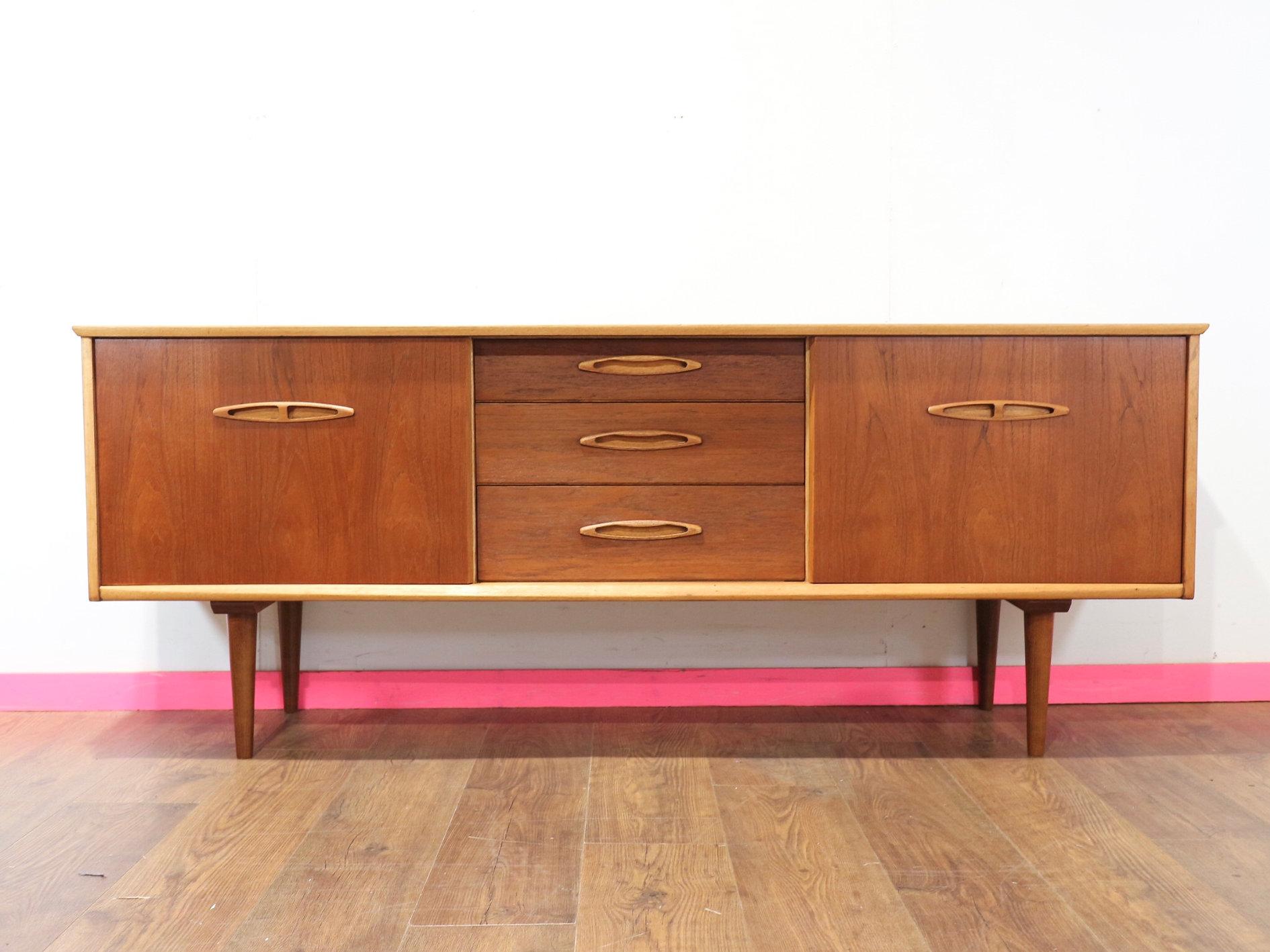 This Mid Century Modern Teak Vintage Danish Style Sideboard Credenza by Jentique is a wonderful example of mid century style, capturing the sleek and sophisticated design aesthetic of the 60s. Crafted from high-quality teak wood, this credenza