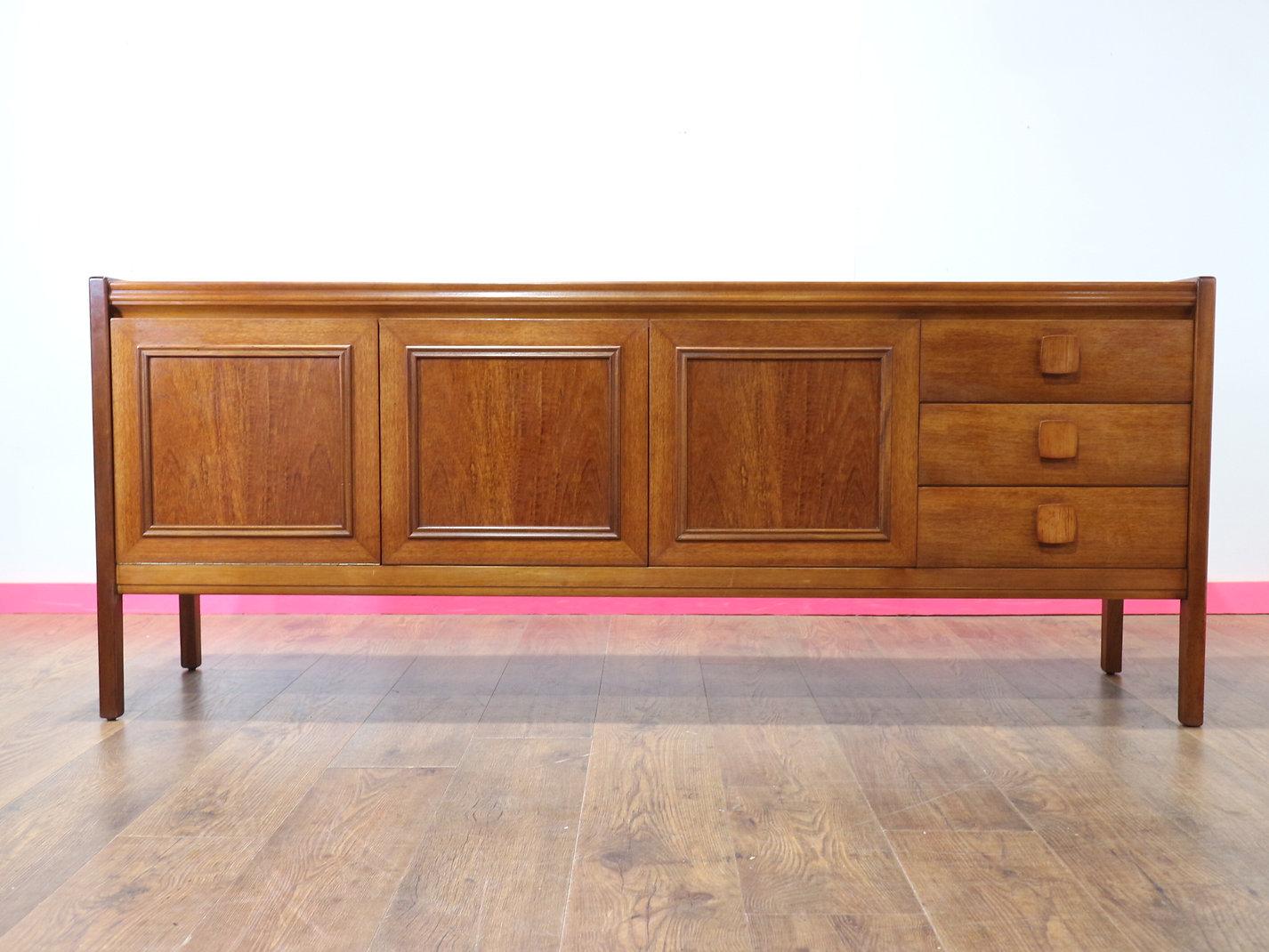 A stunning mid century credenza by renowned British furniture maker Nathan, this vintage teak sideboard exudes timeless Danish style elegance and functionality. Perfect for discerning collectors and design enthusiasts, it offers great storage while