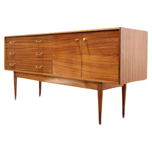 A truly beautiful sideboard by British furniture maker Uniflex, this Mid Century Modern Vintage Teak Credenza is perfect for the discerning collector. The credenza has a beautiful grain and sits gracefully on sculpted legs, making it a standout
