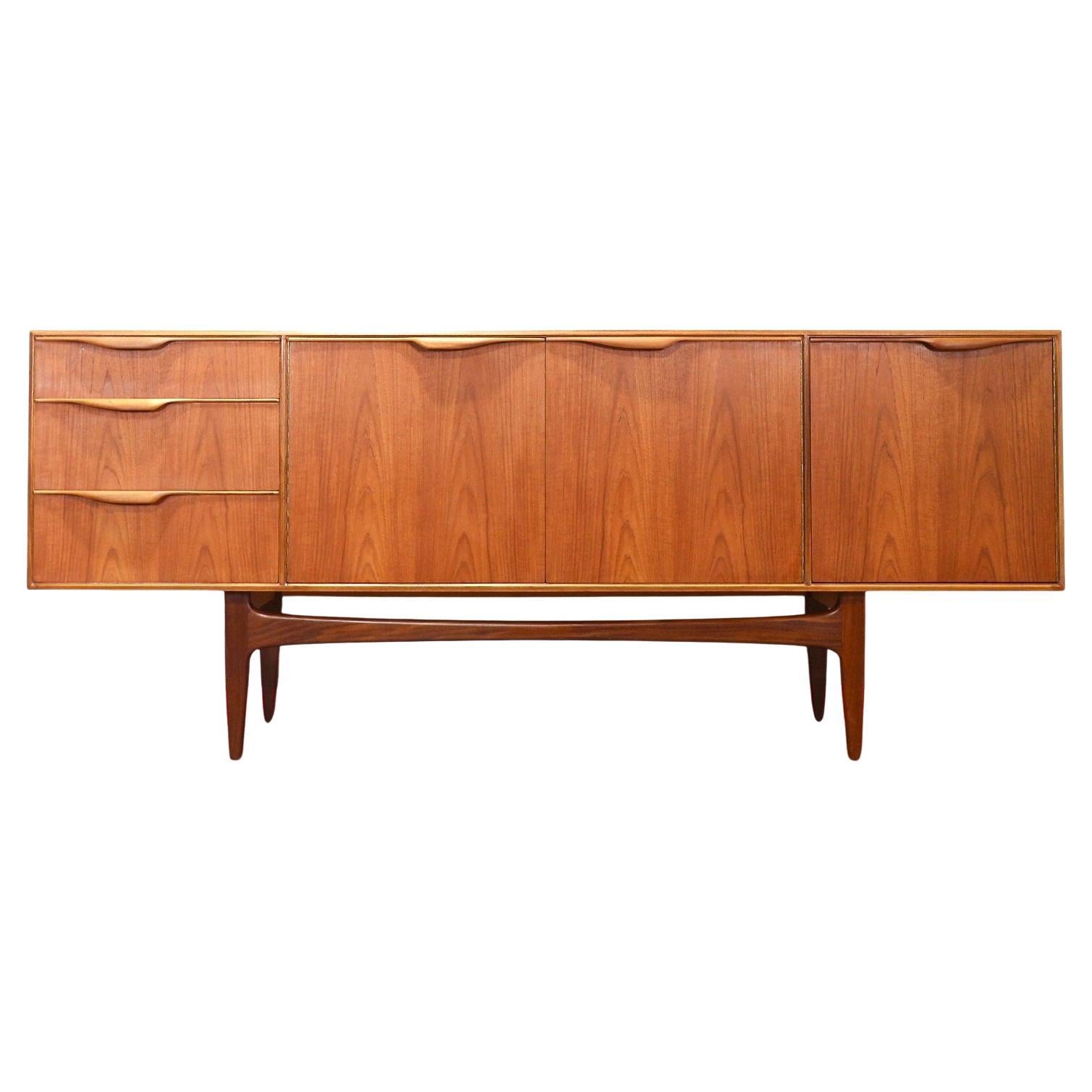 A stunning A.H Mcintosh of Kirkcaldy mid-century  credenza which is part of the Dunvegan range. The sideboard is a stunning and iconic design by Tom Robertson for A H McIntosh Kirkcaldy. This sideboard is well proportionated and light on its feet.