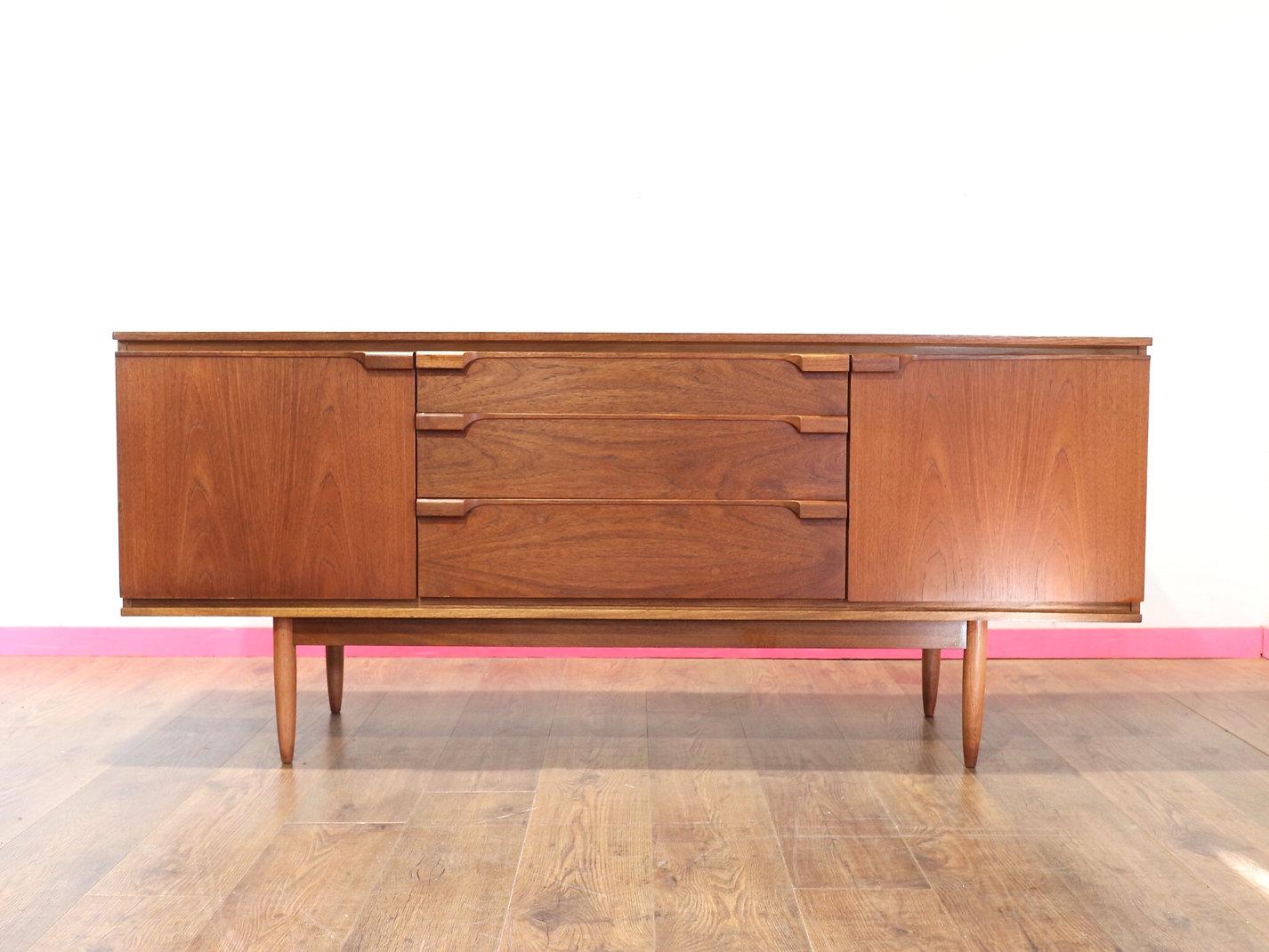 A beautiful credenza by British furniture maker Austinsuite, this Mid Century Modern Vintage Teak Sideboard embodies great style and superior craftsmanship. At Mid Century Traders, we take pride in offering timeless pieces that blend form and