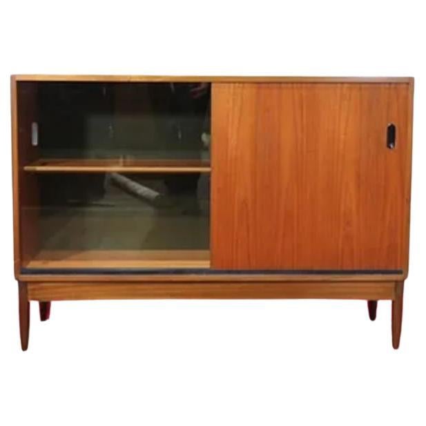 Add a touch of timeless elegance to your home decor with this Mid Century Modern Vintage Teak Danish Style Cabinet by Greaves and Thomas. Crafted in the 1960s, this beautiful piece showcases the exquisite craftsmanship of the renowned British