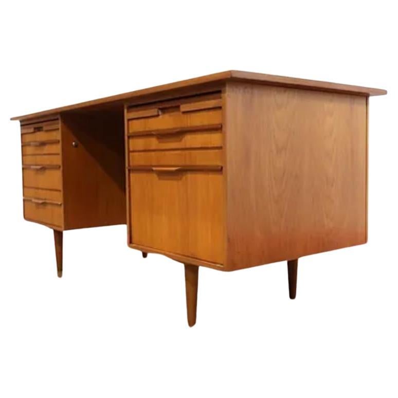 This stunning vintage teak desk embodies the classic Danish mid-century modern design, with clean lines and minimalist aesthetic. Made from high-quality teak wood, this desk exudes timeless elegance and sophistication. The generous storage options