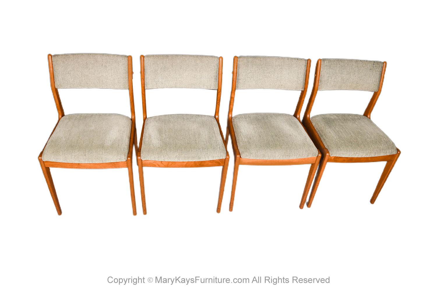 A set of four gorgeous 1960's Danish modern teak dining chairs by famous designer Johannes Andersen, made in Denmark by Uldum Møbelfabrik. Remains in original condition throughout. Features solid teak frames, with curved backrests, and padded seats