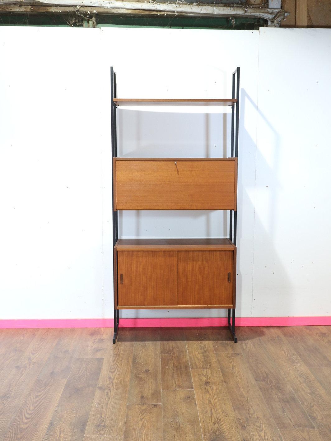 Discover the exquisite Mid Century Modern Vintage Teak Display Bookcase Wall Cabinet by Uniflex. This elegant Mid Century wall unit combines great storage and beautiful style, featuring a sophisticated drop down door bureau for added functionality.