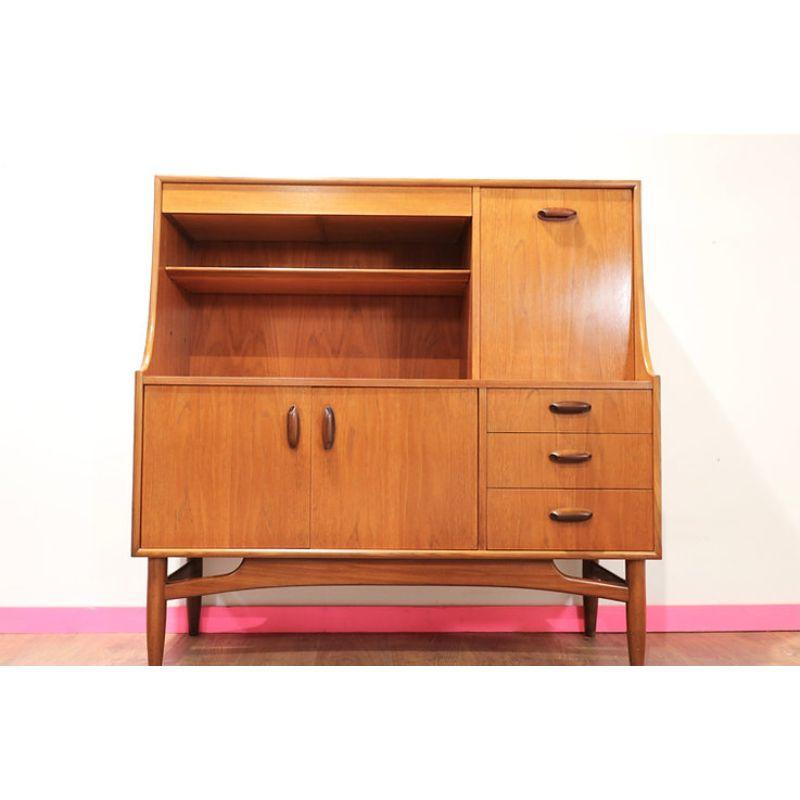 A wonderful Mid Century Vintage Teak G Plan Highboard credenza with Cocktail Cabinet, Drawers and  spacious cupboards. Set on an elegant but sturdy solid teak leg frame which illustrates the quality of the design and craftsmanship of the piece. The