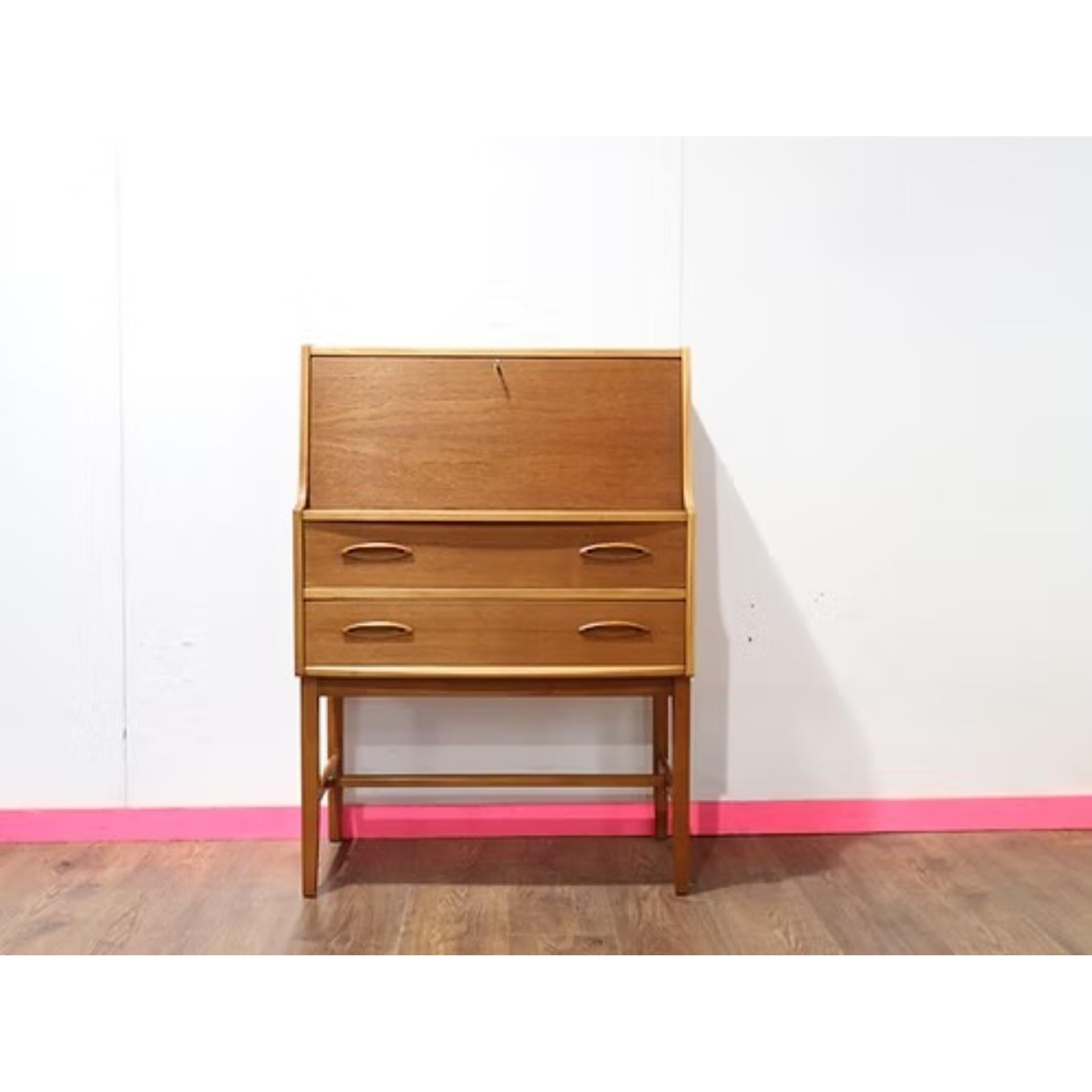 Le bureau sécretaire vintage en teck de Jentique est un ajout étonnant à toute collection de meubles du milieu du siècle. Fabriqué par le célèbre fabricant de meubles britannique Jentique, ce bureau présente les lignes épurées et le design élégant