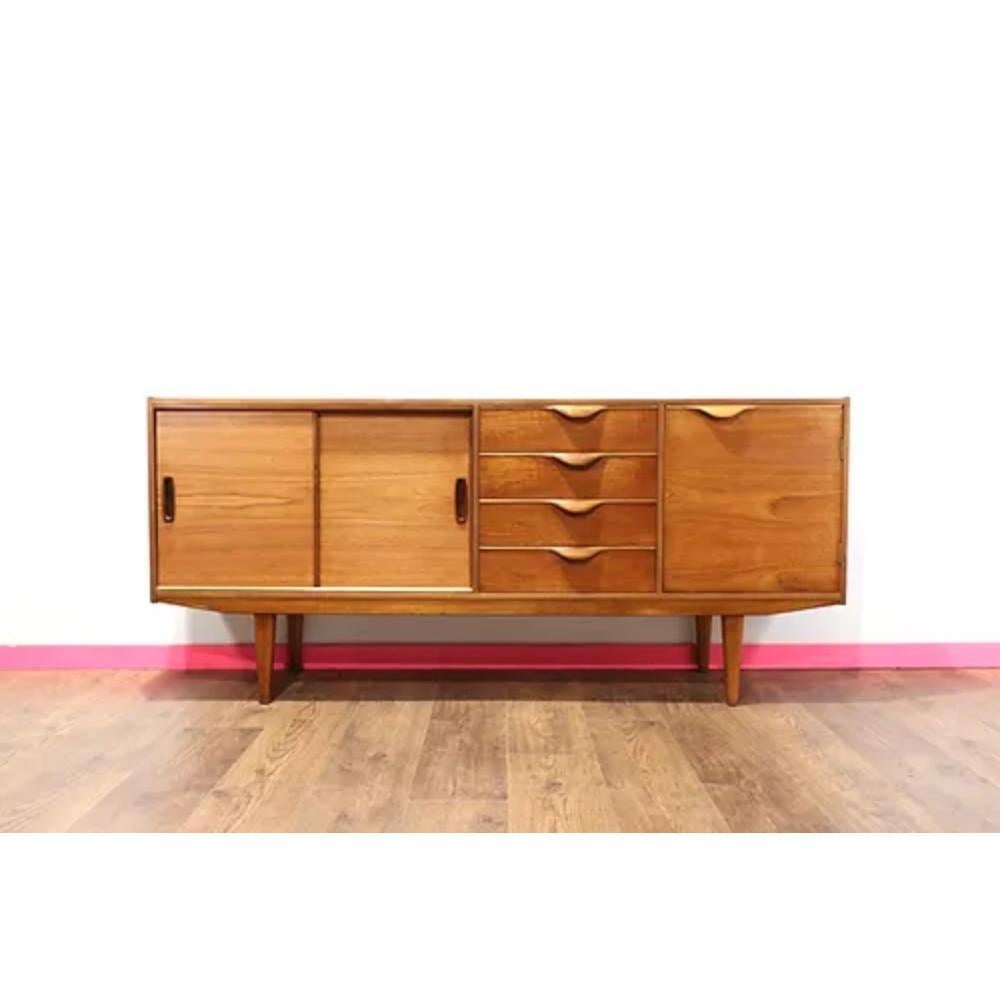 Introducing the Mid Century Modern Vintage Teak Sideboard Credenza by Sutcliffe, a stunning piece of mid-century furniture that will add elegance and functionality to any space. Crafted with high-quality teak wood, this credenza features beautiful