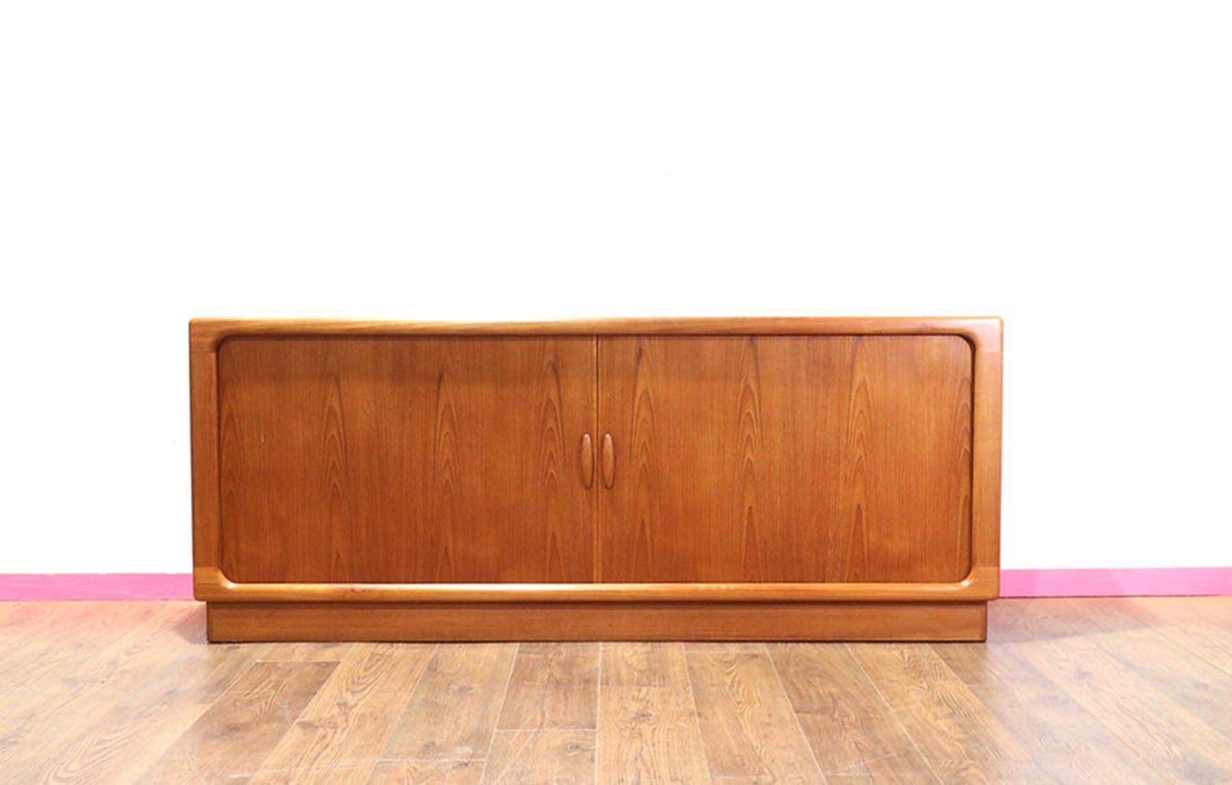Discover a stunning credenza by Danish furniture maker Dyrlund, featured at Mid Century Traders. This exquisite piece showcases elegant tambour doors and offers great storage, making it a perfect blend of style and functionality. At Mid Century