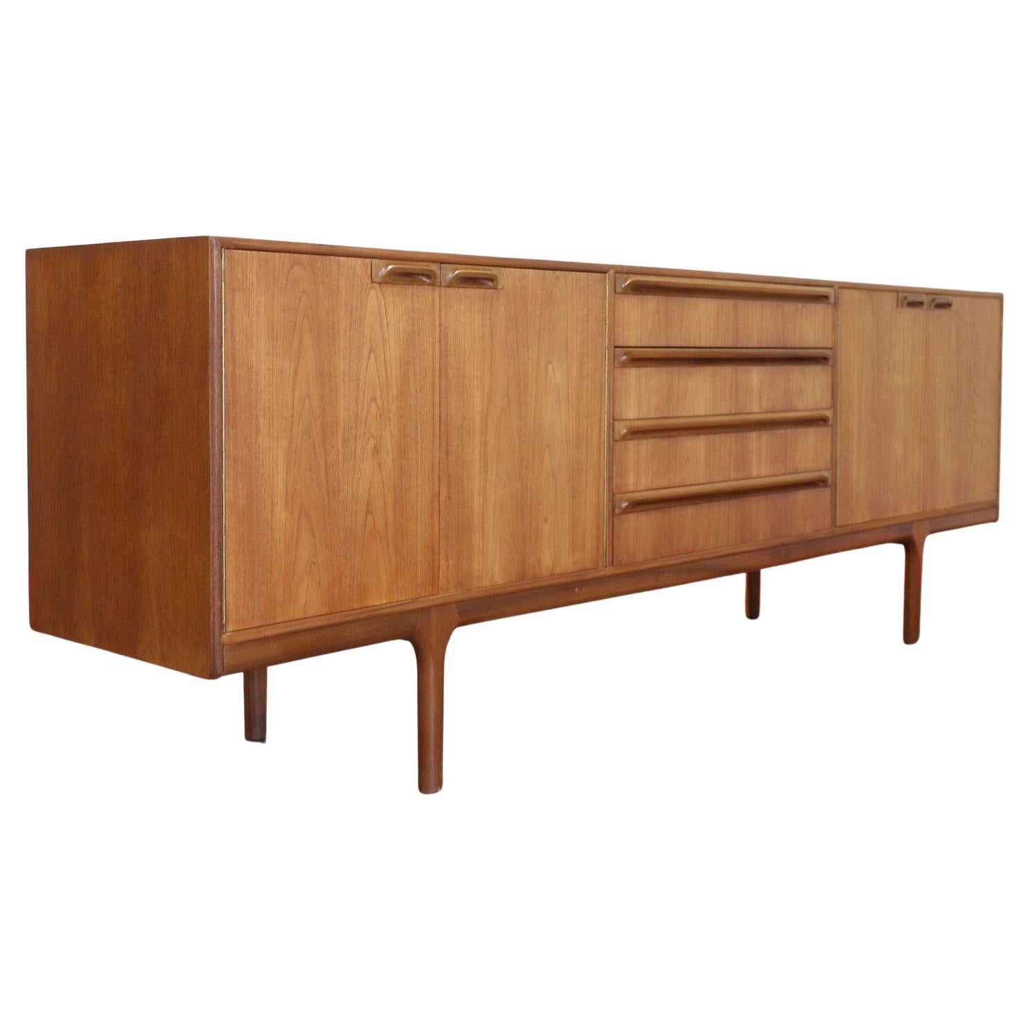 Discover this stunning mid century sideboard by renowned Scottish furniture maker, Mcintosh. This vintage teak sideboard offers great storage, making it both a practical and beautiful addition to any home. Its design features gorgeous handles that