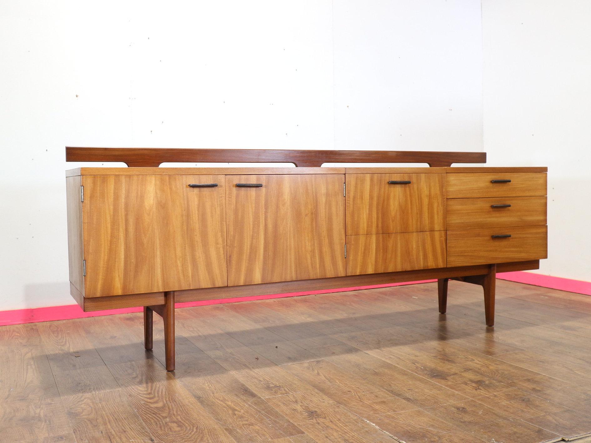 Rehaussez votre espace de vie avec le buffet en teck Gunther Hoffstead d'Uniflex, disponible chez Mid Century Traders. Cette pièce exquise est dotée d'un dossier bas à barreaux et d'un plateau avec un panneau de marbre encastré, offrant à la fois