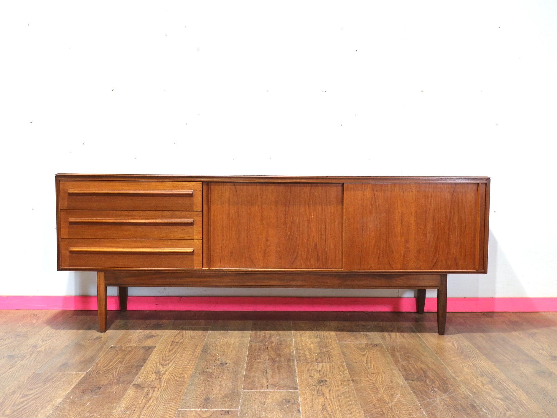 Discover a stunning mid-century credenza by renowned furniture maker White and Newton, exclusively available at Mid Century Traders. This exquisite piece features beautiful handles and sliding doors, offering great storage while embodying timeless