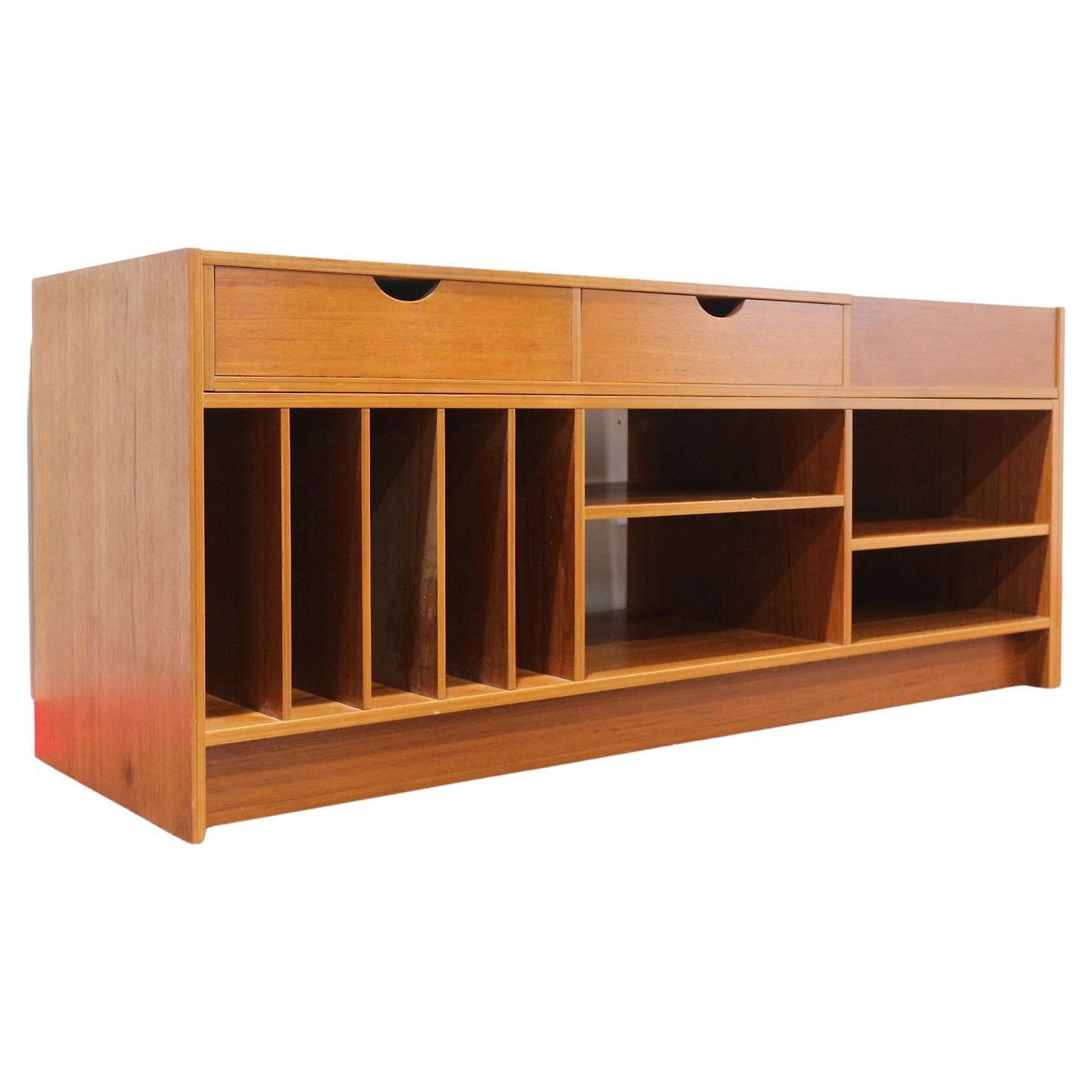 Mejora tu salón con este fabuloso mueble para discos versátil de teca de Mid Century Traders. Con gran capacidad de almacenamiento, esta elegante pieza se extiende y encaja perfectamente en cualquier rincón, ofreciendo una mezcla perfecta de