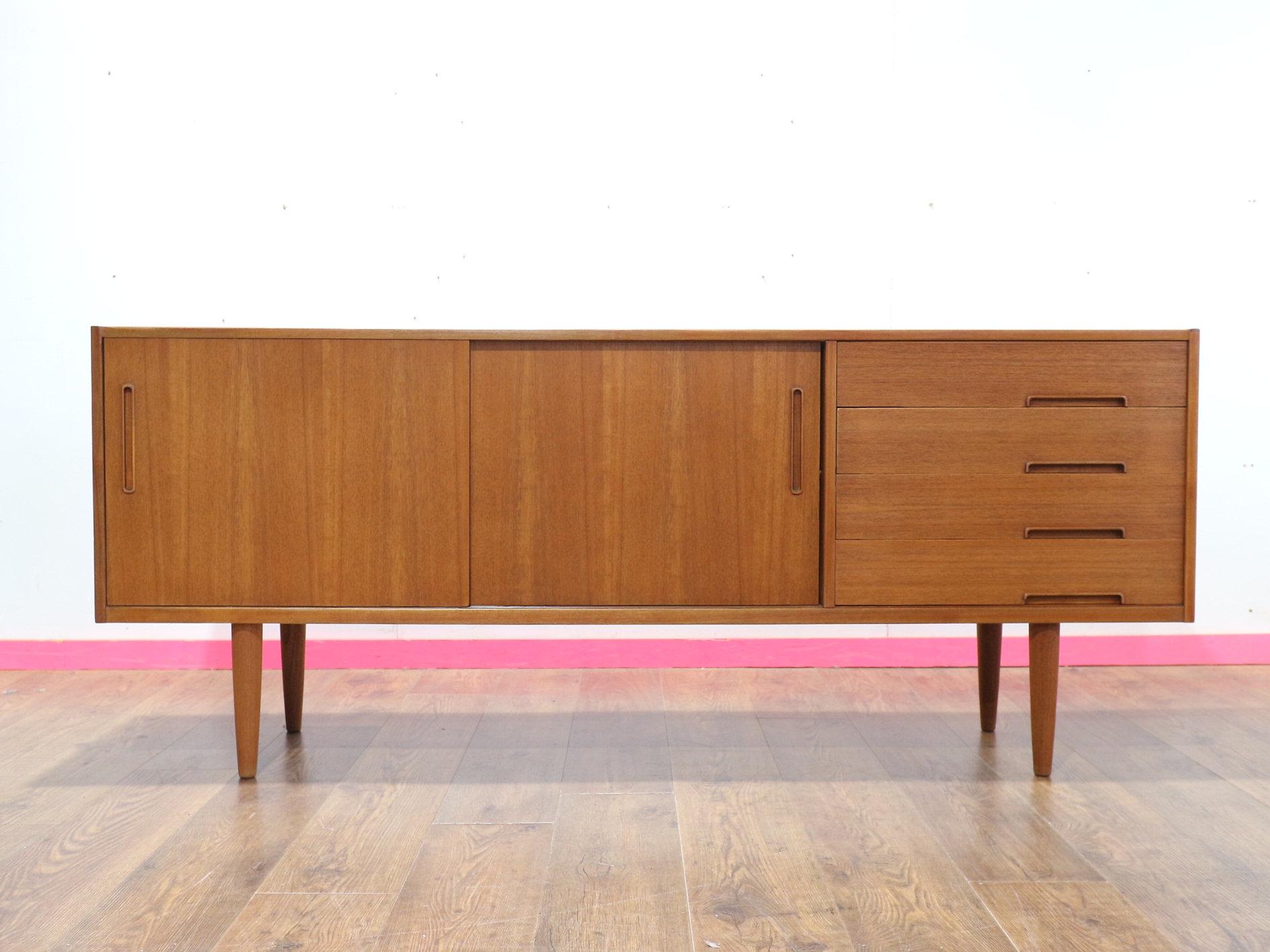 Experience timeless elegance with our Mid century modern Swedish credenza by Nils Jonsson, available at Mid Century Traders. This exquisite piece, designed in true Scandinavian style, offers not only exceptional aesthetic appeal but also great