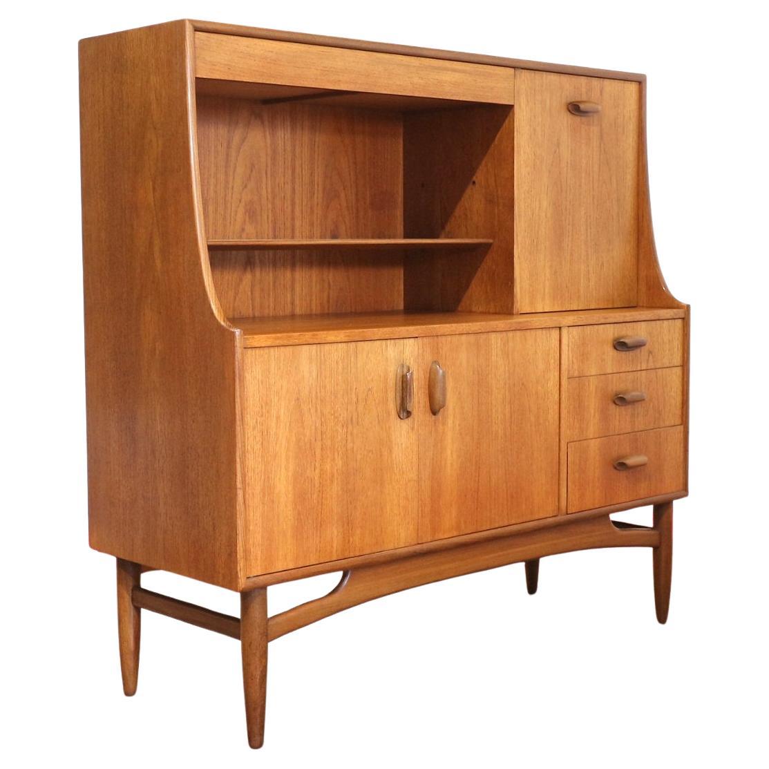 Introducing thid Mid Century Modern Teak Brasilia Short SidebTall oard Credenza Buffet by G Plan, a stunning piece from the iconic Brasilia range. Crafted by the renowned British cabinet maker, G Plan, this tall credenza exudes timeless style and