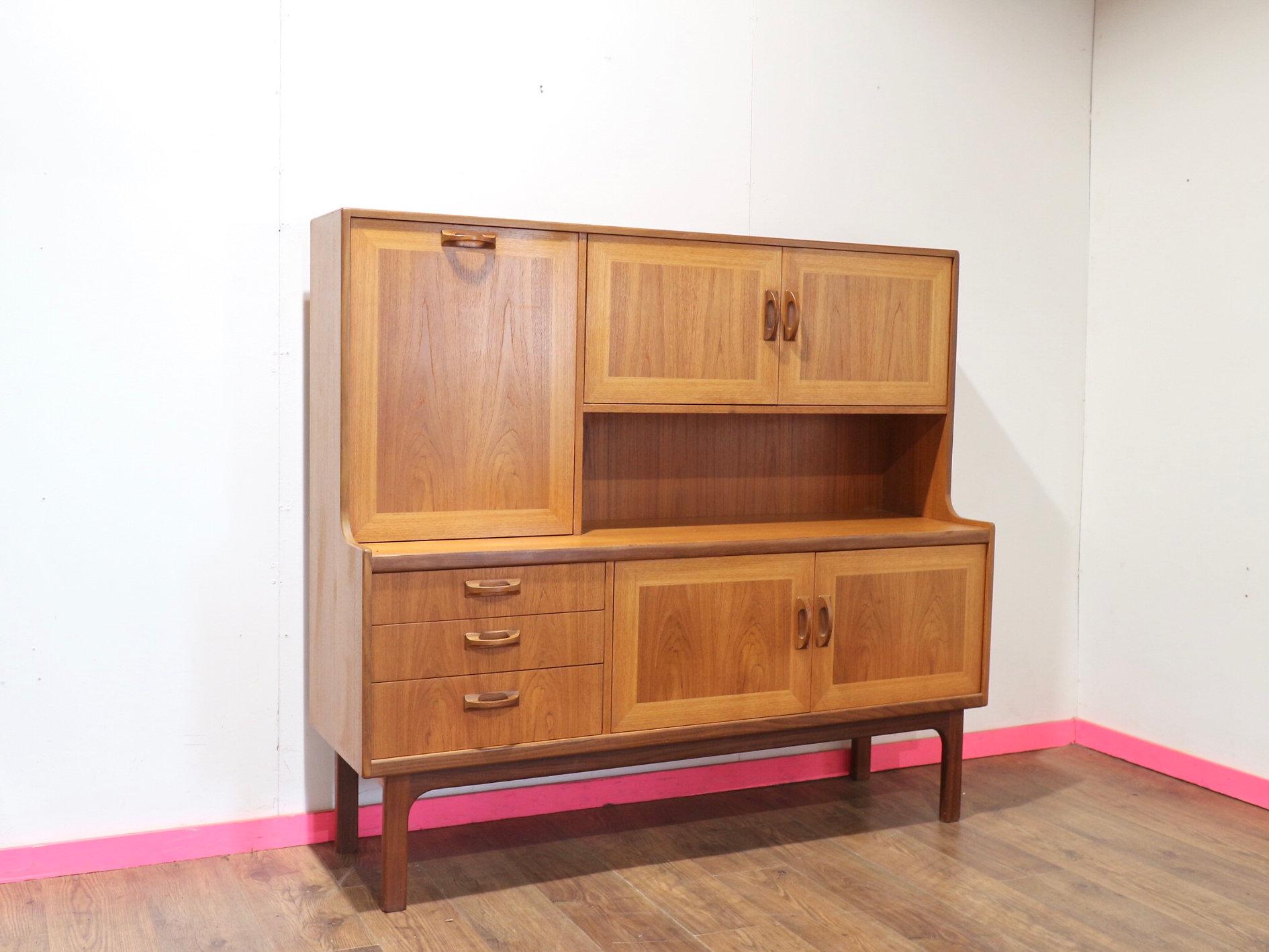 Remontez le temps avec le Buffet crédence vintage en teck de G-Plan. Faisant partie de la gamme distinguée G-Plan Sierra, cette crédence haute en teck allie un style danois intemporel à un savoir-faire artisanal exceptionnel. Doté d'une grande