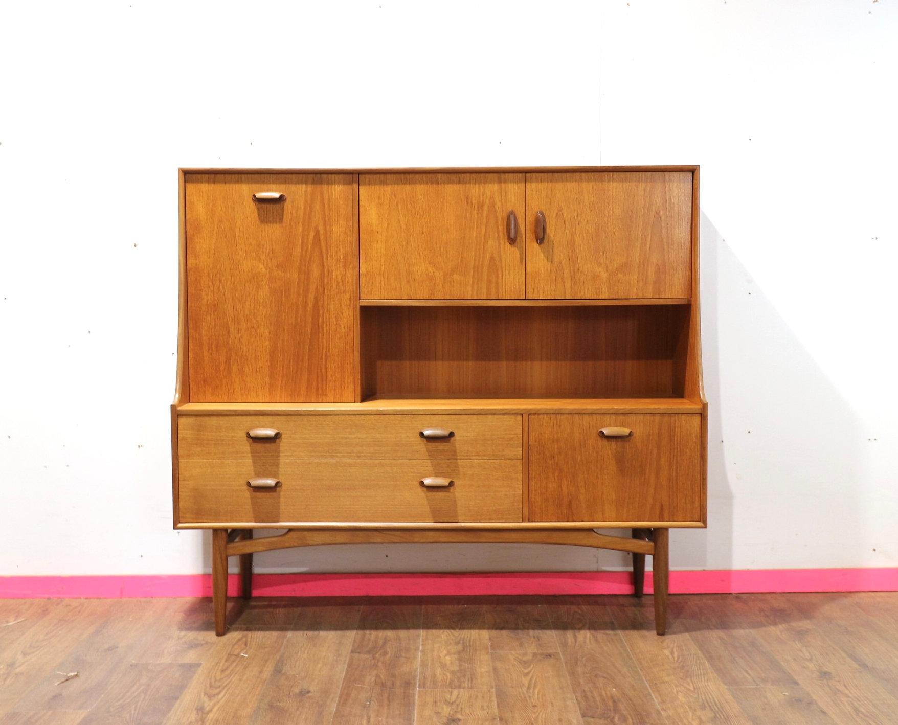 Introducing the Mid Century Modern Teak Brasilia Sideboard Tall Credenza Buffet by G Plan, a stunning piece from the iconic Brasilia range. Crafted by the renowned British cabinet maker, G Plan, this tall credenza exudes timeless style and