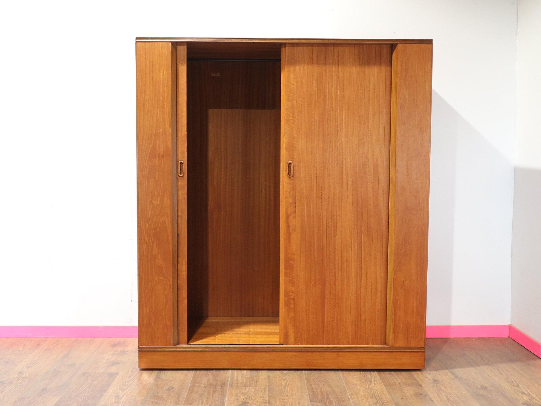 A gorgeous teak armoire wardrobe by British furniture maker Austinsuite, this Mid Century Modern piece from Mid Century Traders provides both elegance and functionality for your home. Featuring stunning tambour doors, it offers an exquisite blend of