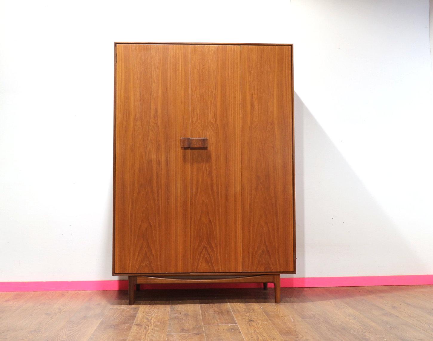 This stunning wardrobe armoire by G plan is part of their Danish range and designed by renowned designer, Kofod Larsen. Made from teak and teak veneer, it has ample storage space whilst looking super stylish with its sculpted handles. At Mid Century
