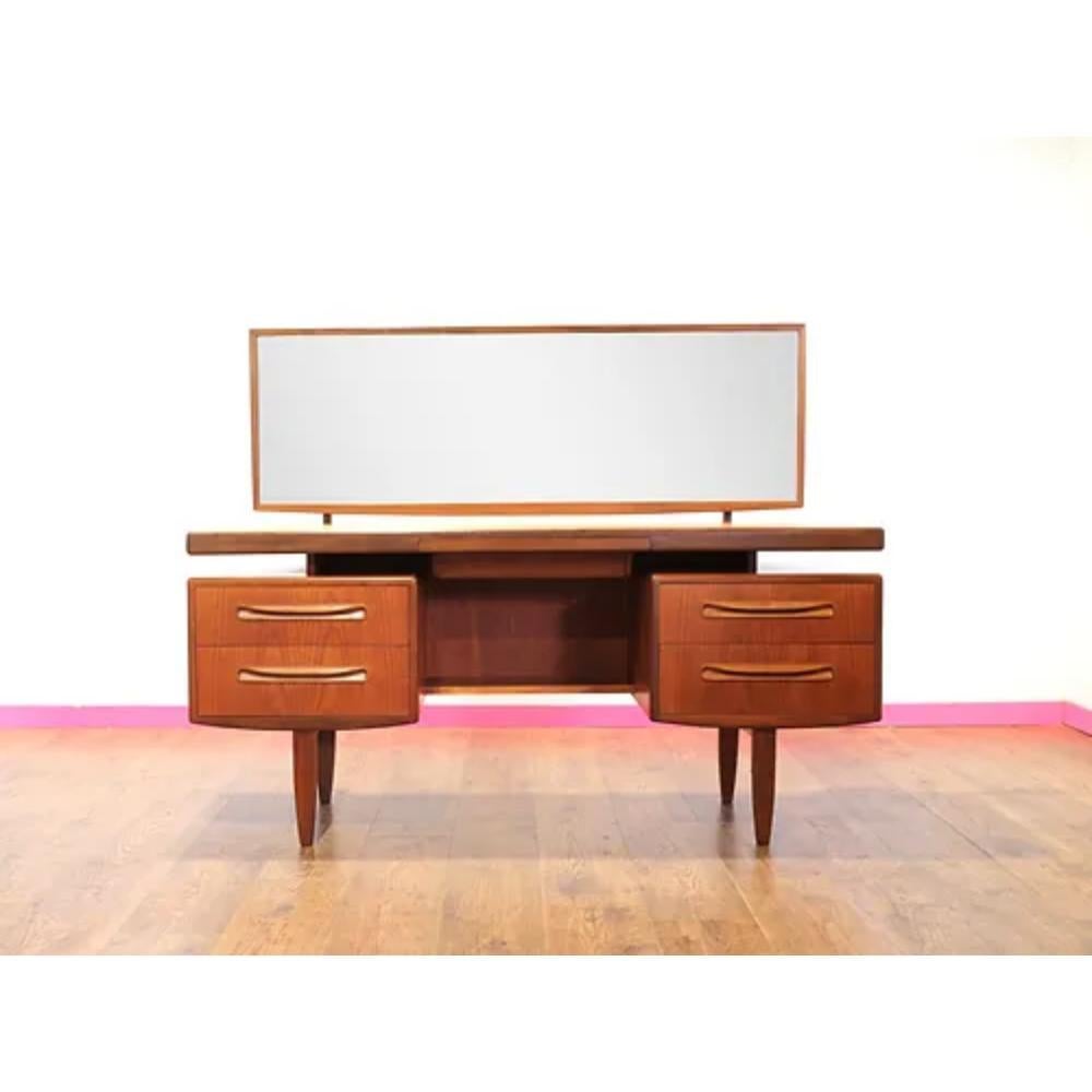 Elevate your bedroom décor with this exquisite Mid Century Modern Vintage Teak Vanity Dressing Table by G Plan. Crafted by the renowned British furniture maker, G Plan, this stunning vanity is a true testament to the mid century modern design